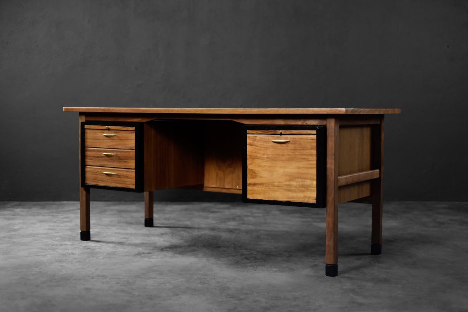 This modernist desk was manufactured in Denmark during the 1960s. It is finished in natural teak wood in a warm shade of brown, with visible grain detail. The piece features three spacious drawers on the left side, ideal for storing documents,