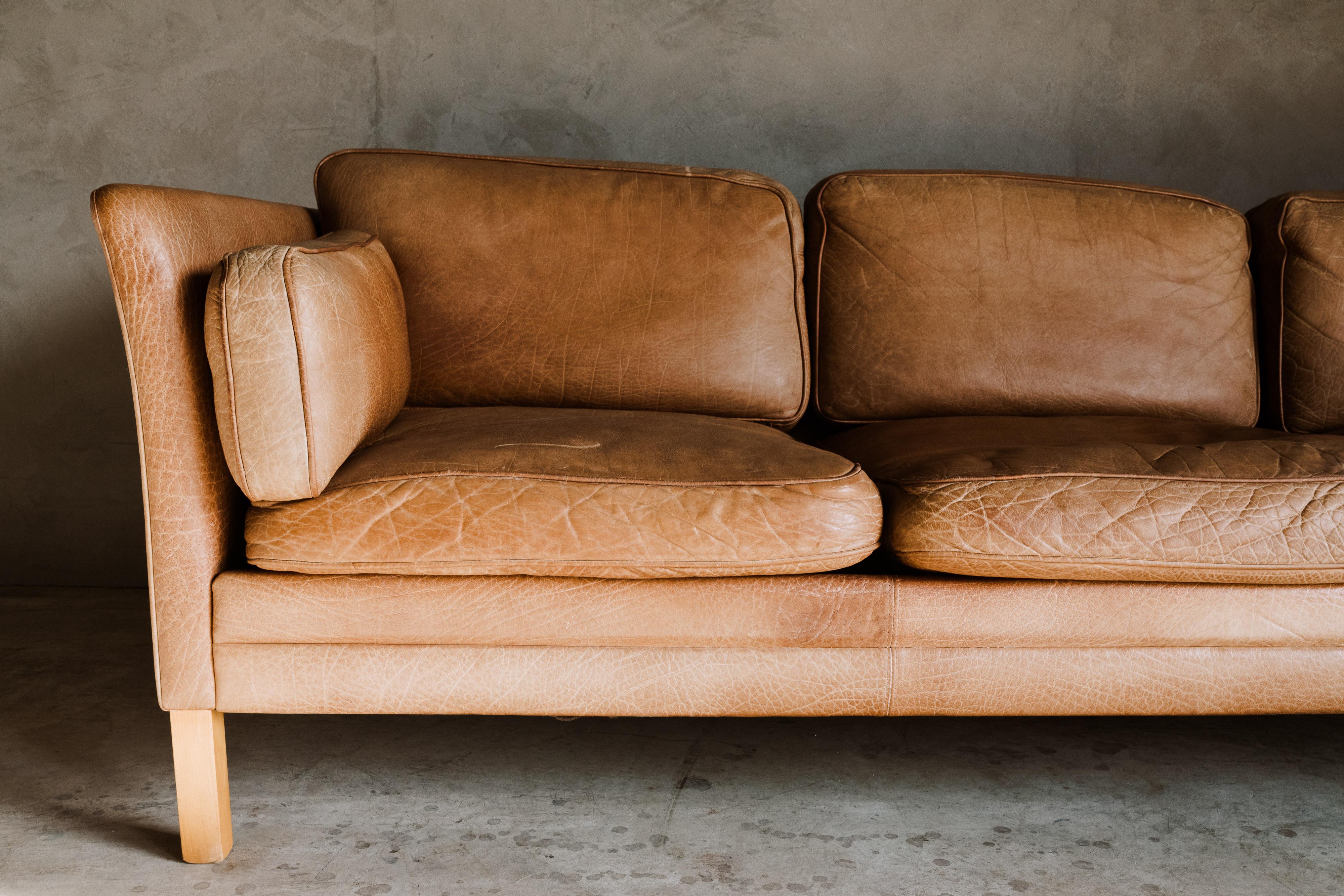 Vintage midcentury leather sofa from Denmark, circa 1970. Original cognac leather upholstery with fantastic color and patina.