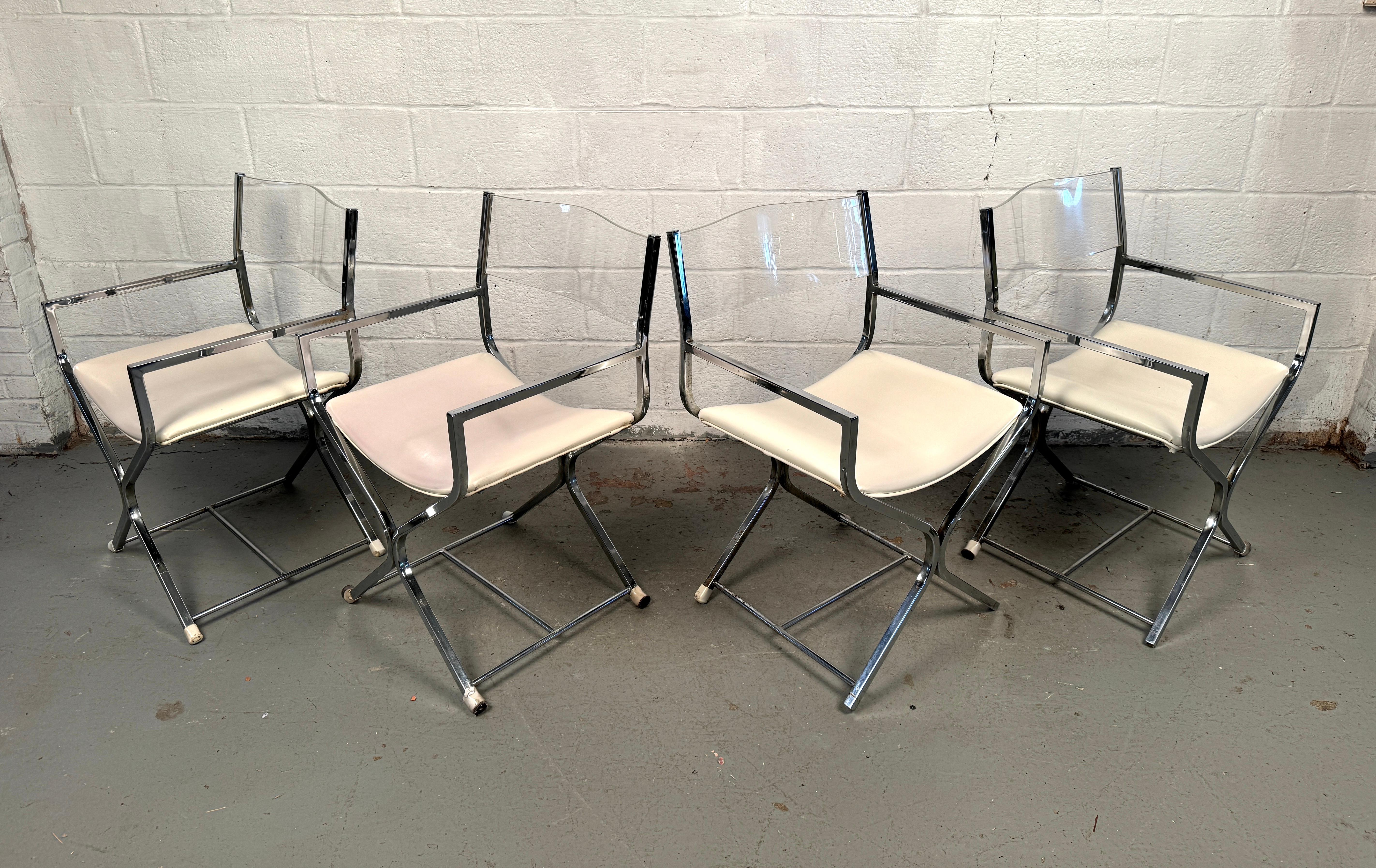 Questo set di quattro sedie da regista vintage in lucite e cromo è un'audace dichiarazione di raffinatezza di metà secolo. Eleganti, scultoree e di grande effetto, queste sedie sono un mix sorprendente di materiali moderni e forme senza tempo,