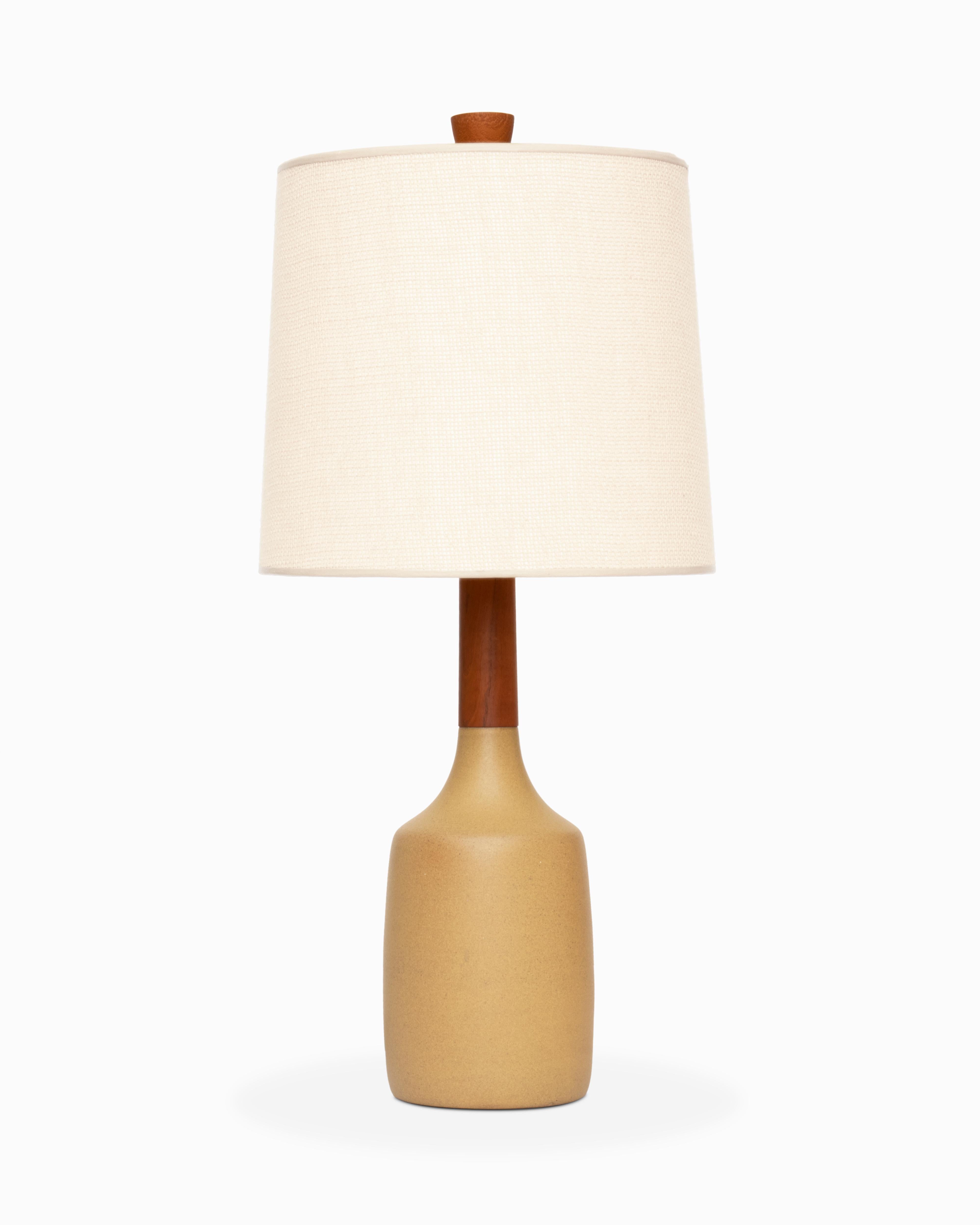 Voici une magnifique table en céramique réalisée par Jane et Gordon Martz / Marshall Studios. Le modèle 208 présente une forme subtile de bouteille avec un long col en teck. Cet exemple est dans une couleur de glaçure 