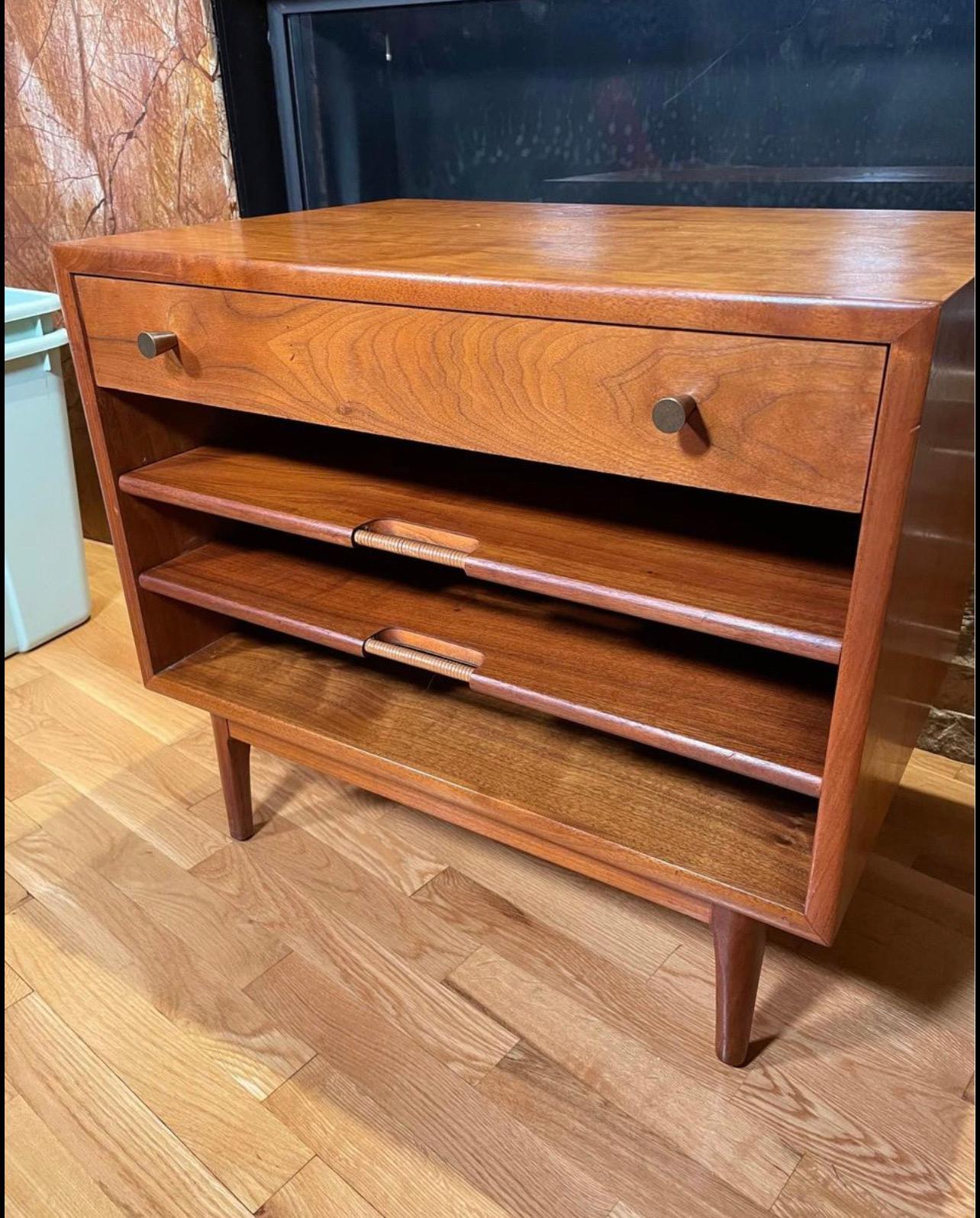 A gorgeous vintage MCM walnut side table designed by Kipp Stewart for Drexel. It features pull out shelves, perfect for magazines, newspapers and books, and an upper drawer. Could be used as an end or side table, nightstand, or accent piece for a