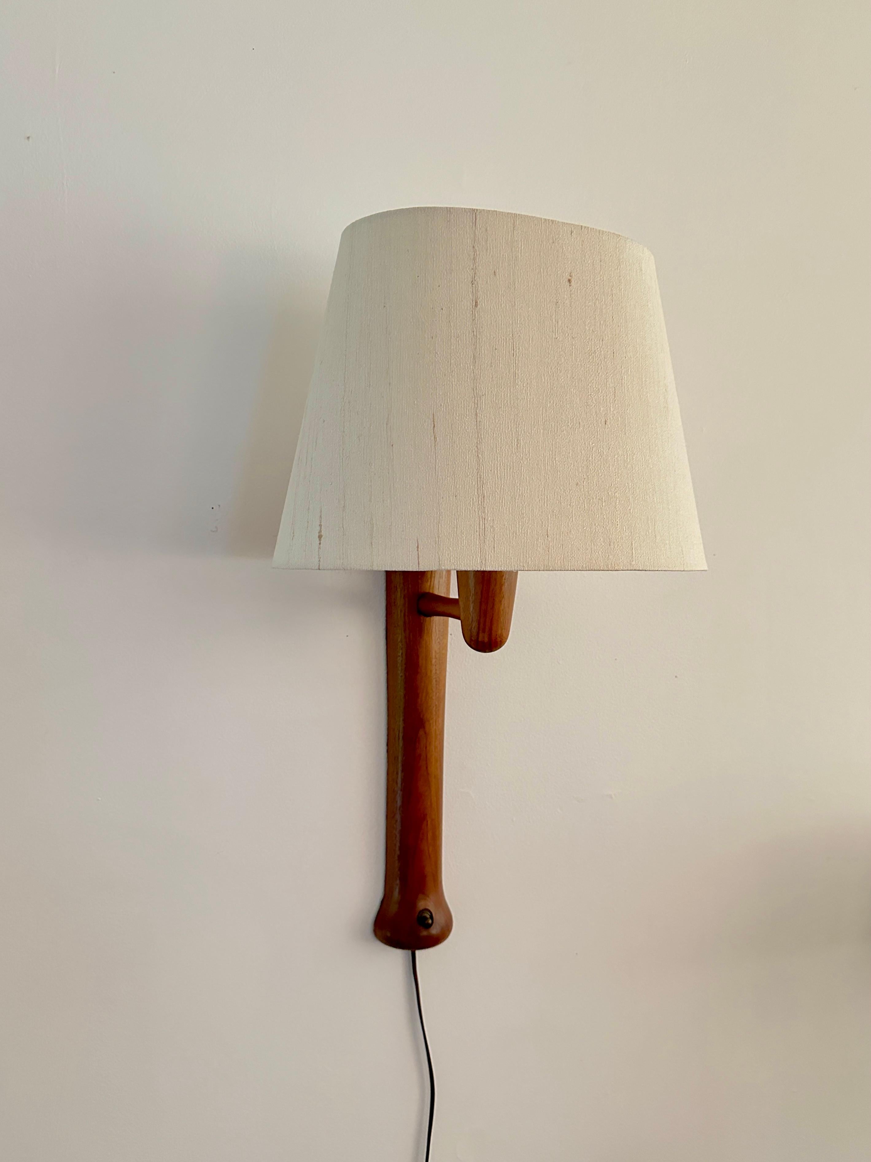 A wall sconce from Marshall Studios, Inc, Veedersburg, Indiana. The sconce first appeared in a 1966 Marshall Studios catalog. The model number was T12 and described as being made of teak.

Marshall Studios, Inc. initally started out as makers of