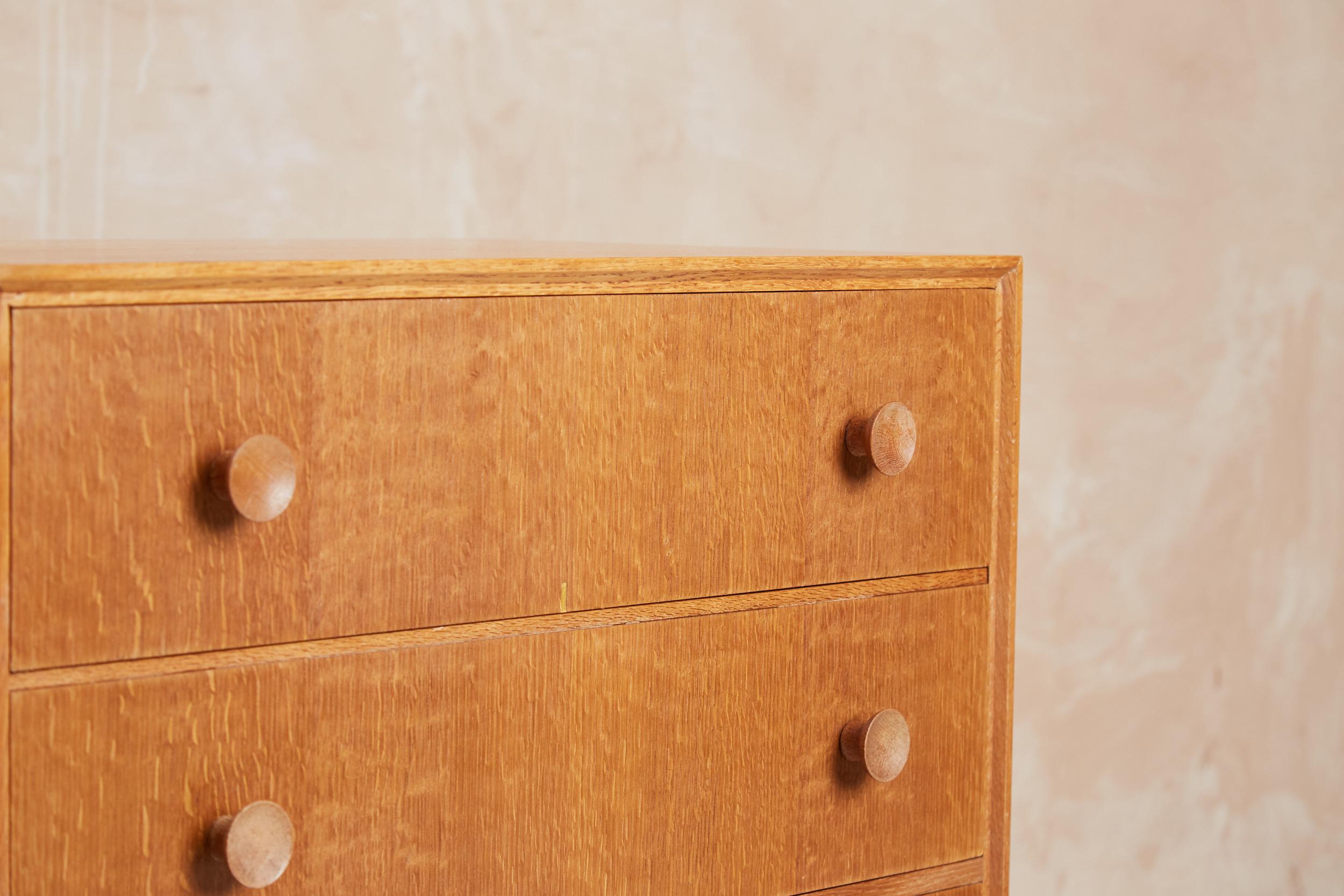Stylishly simple chest of four drawers by Meredew from the early 1960s. Beautiful blonde oak finish which is smooth to touch with a characterful grain. Good size drawer depth and the iconic concave protruding round handles which give balance to the
