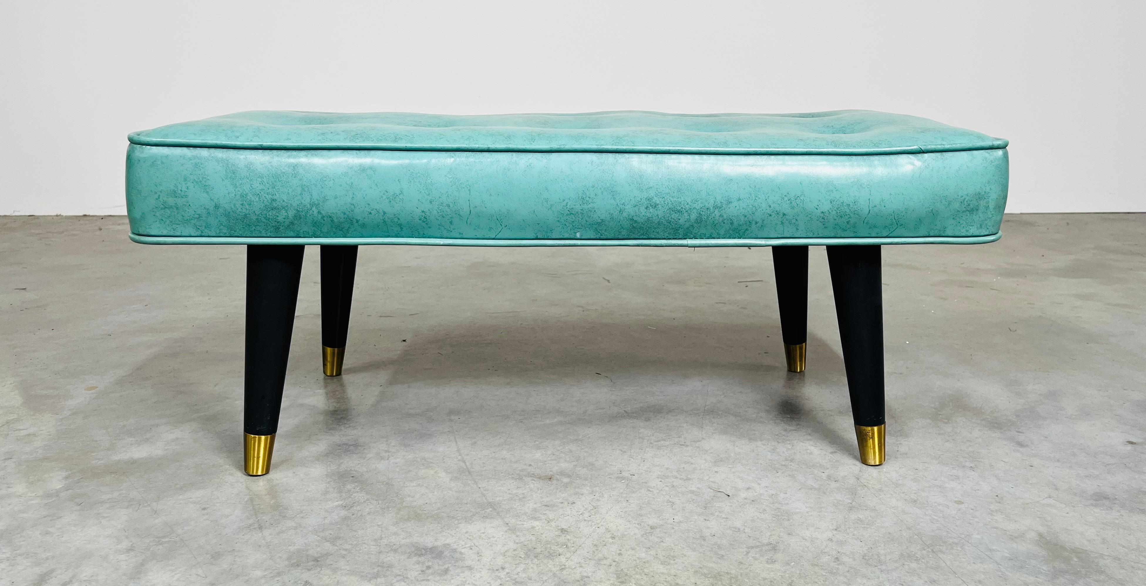 Un design classique du milieu du siècle à la manière de Milo Baughman, avec un excellent rembourrage en Naugahyde turquoise tufté sur des pieds ébonisés évasés avec des pieds sabot à coupelles en laiton. 
En excellent état de propreté, sans trous,