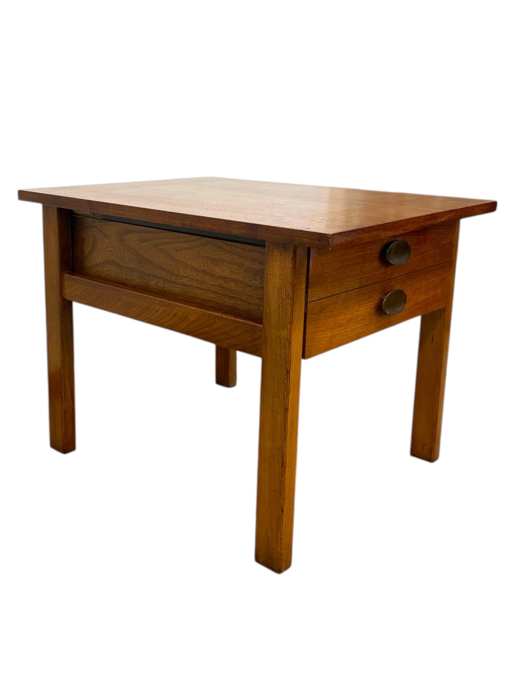 Esta mesa auxiliar vintage de mediados de siglo fue fabricada por Lane Furniture de Altavista, Virginia. Construida en madera de tonos cálidos, la mesa presenta líneas limpias y una silueta minimalista característica de la época. Incluye un único
