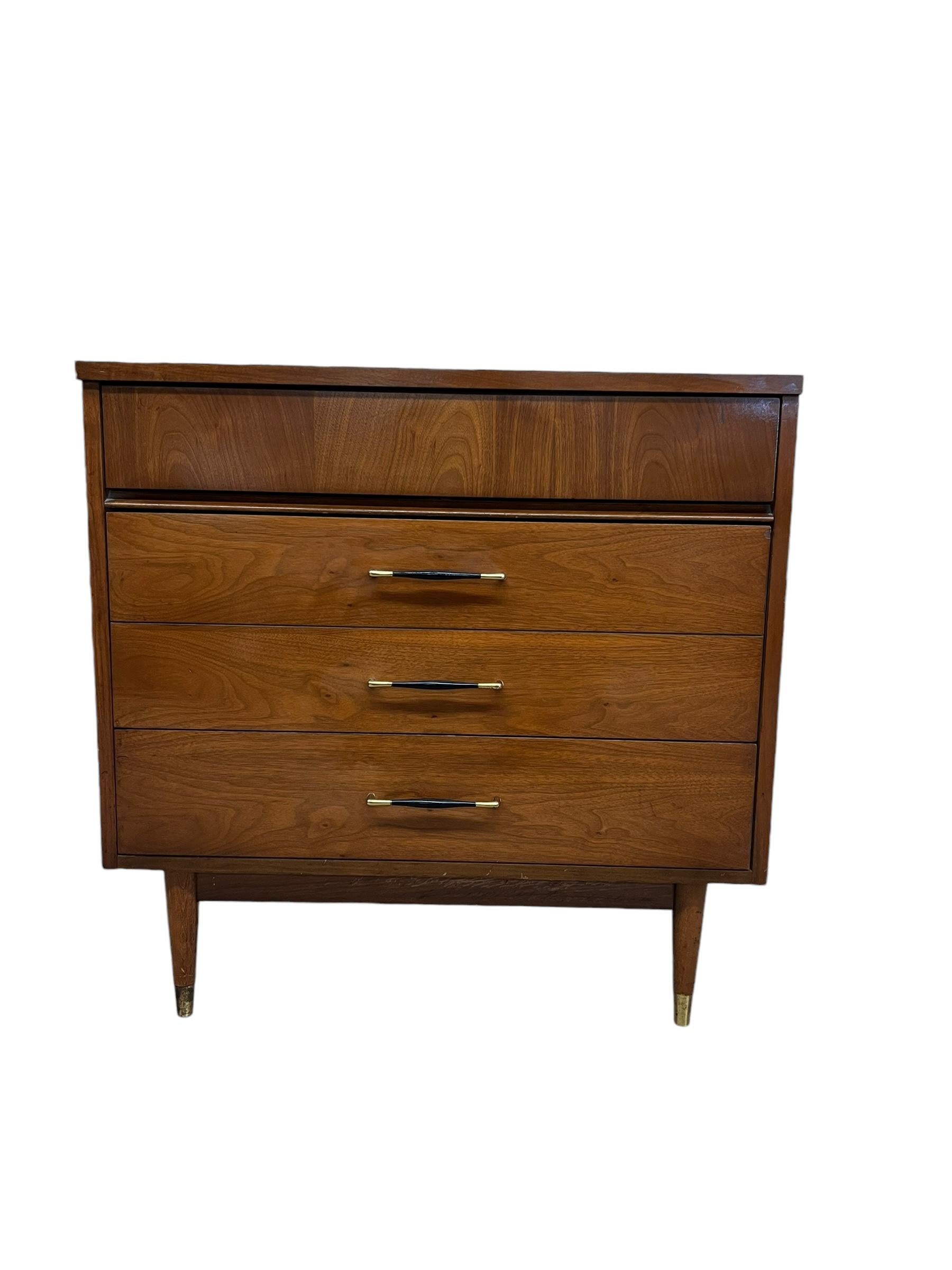  This stylish vintage modern dresser features a walnut finish and spacious three drawer configuration offering plenty of bedroom storage.The clean modern lines of the mid-century design make a striking vintage addition to any interior while the faux