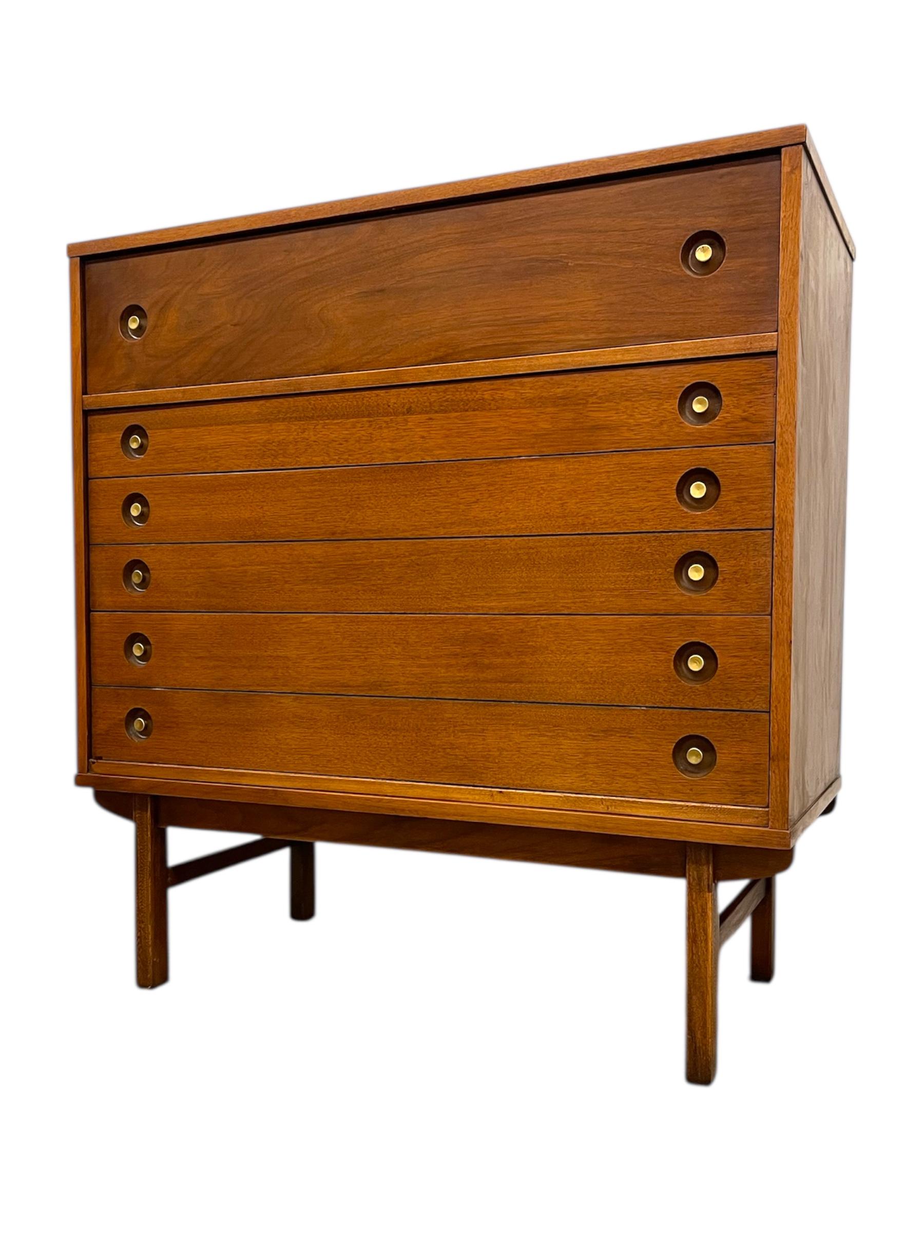 This vintage mid-century modern dresser features clean lines, warm wood grain, and classic craftsmanship characteristic of the 1960s era. The piece is designed with four spacious dovetailed drawers that open smoothly, providing ample storage for