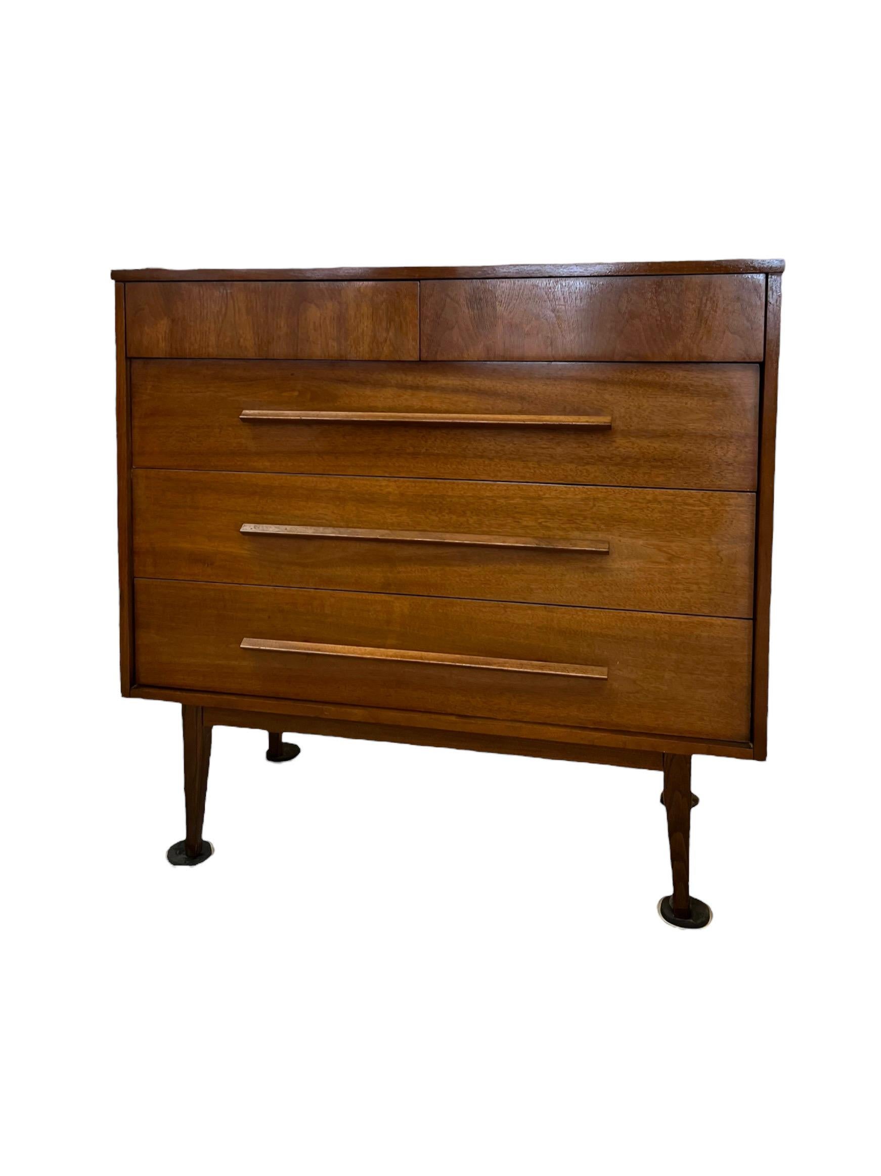 A nice dark cherry mid century dresser with two smaller upper drawers and three larger lower drawers with matching long streamline solid wood pull handles. A very clean design that works well with many different decors having plenty of storage and