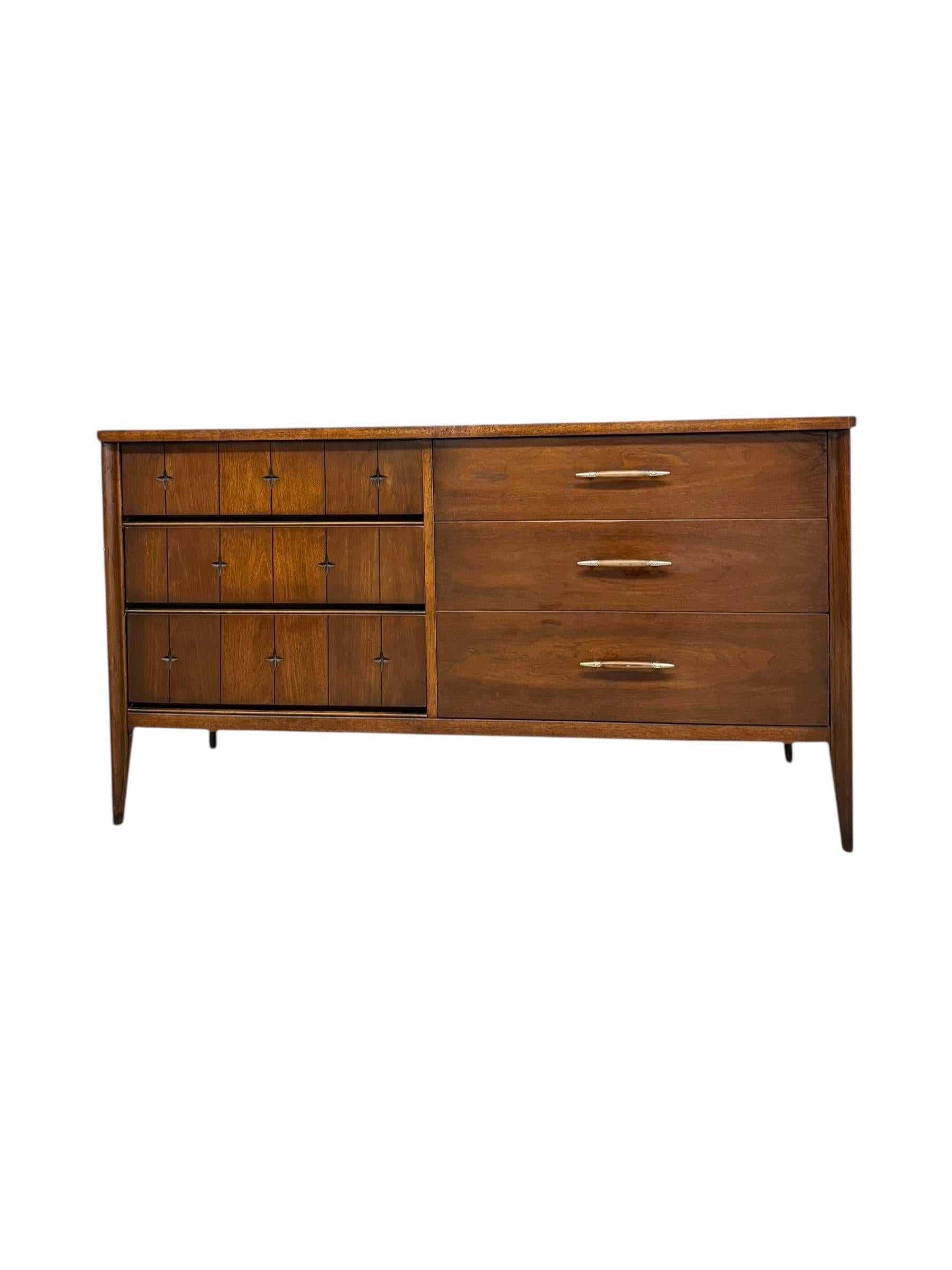 Questo comò a 6 cassetti in noce Vintage Mid Century Modern della linea Broyhill Saga è la quintessenza degli anni '60, realizzato in ricco noce con una finitura liscia e satinata che ne mette in risalto le calde venature. Caratterizzato da un