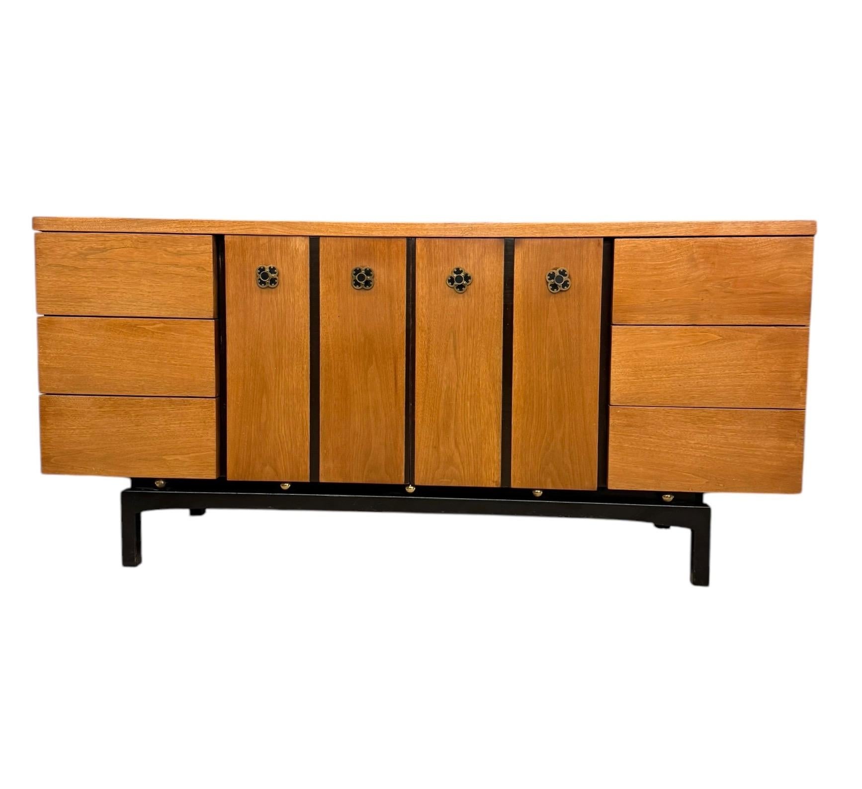 Esta cómoda moderna de mediados de siglo con nueve cajones es una mezcla de elegancia vintage y diseño funcional, perfecta para añadir un toque retro a cualquier dormitorio o sala de estar. Fabricada en cálida madera de tono miel con un elegante