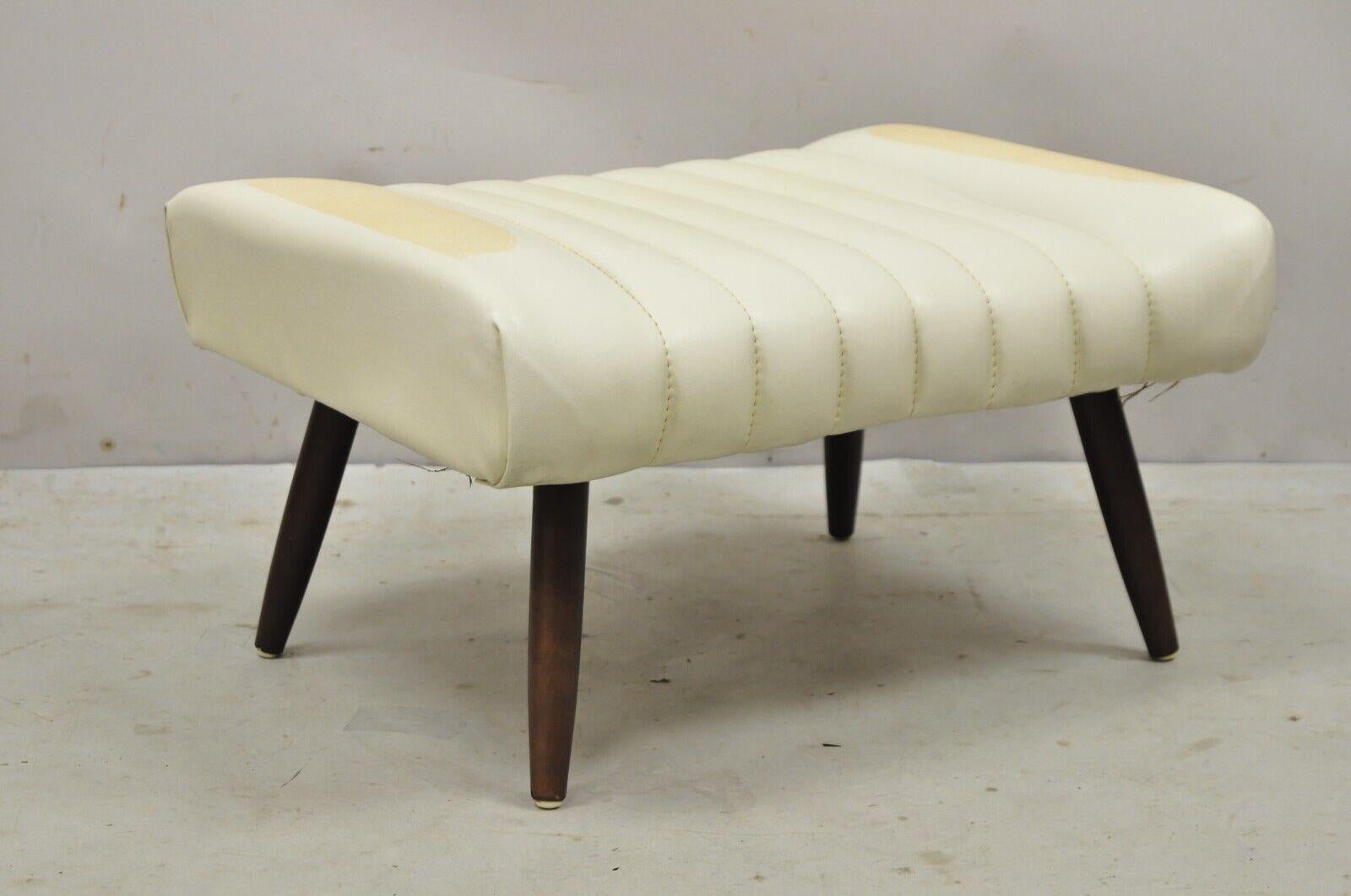 Vintage Mid-Century Modern adjustable angle ottoman footstool with wooden legs. Item features adjustable height / angle, tapered wooden legs, beige vinyl upholstery, very nice vintage item, sleek sculptural form. circa mid 20th