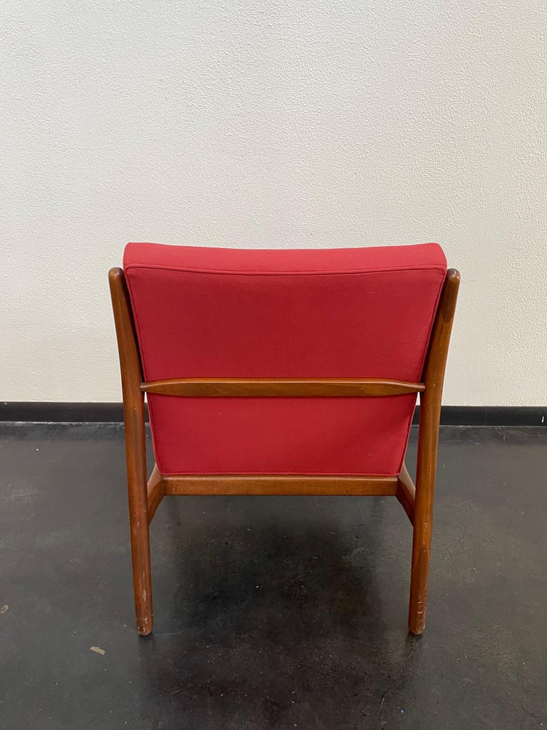 Beautifully minimalist and sleek Mid-Century Modern arm chair with a true red upholstery.