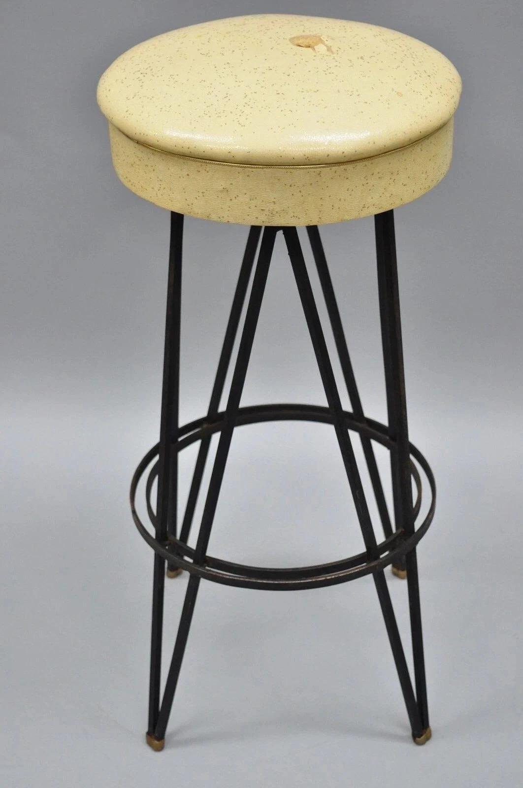 Vintage Mid Century Modern Atomic Era Swivel Wrought Iron Metal Hairpin Bar Stool. Item features a swivel seat, heavy wrought iron construction, yellow vinyl upholstered seat with glitter, original label, quality American craftsmanship. Circa Mid
