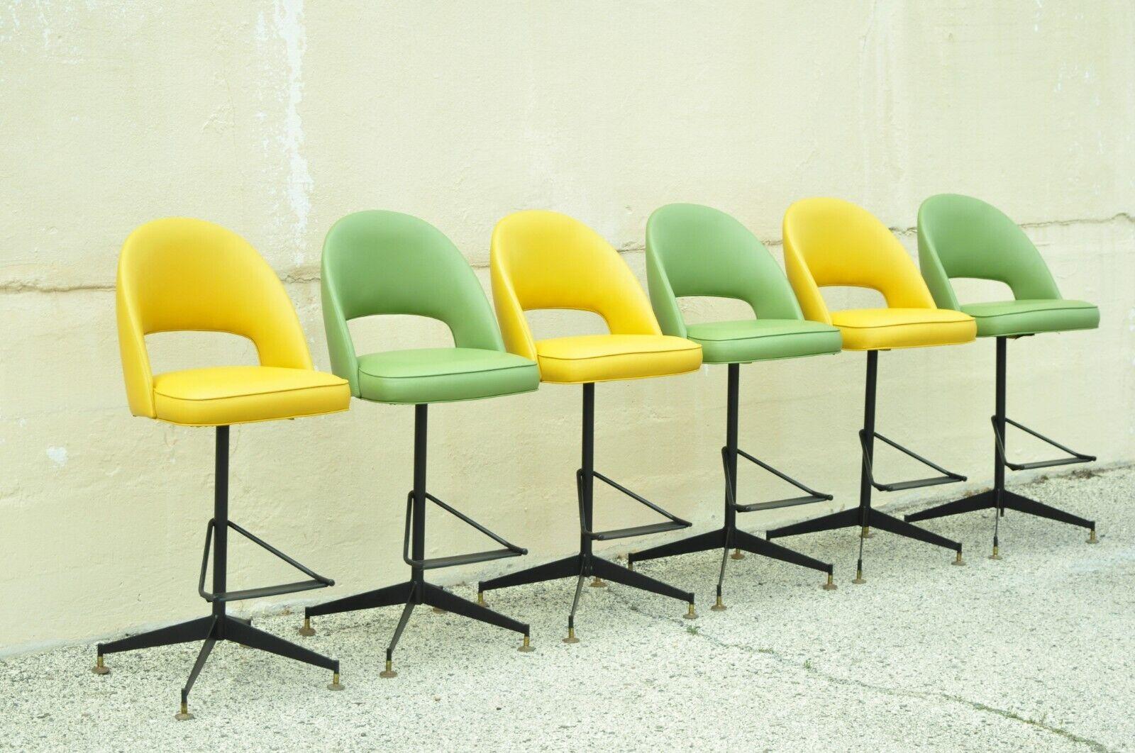 Vintage Mid-Century Modern atomic era yellow & green vinyl bar stools - set of 6. Item features a swivel and return seats, original green and yellow vinyl upholstery, very nice vintage set, sleek sculptural form, (3) green, (3) yellow. Circa