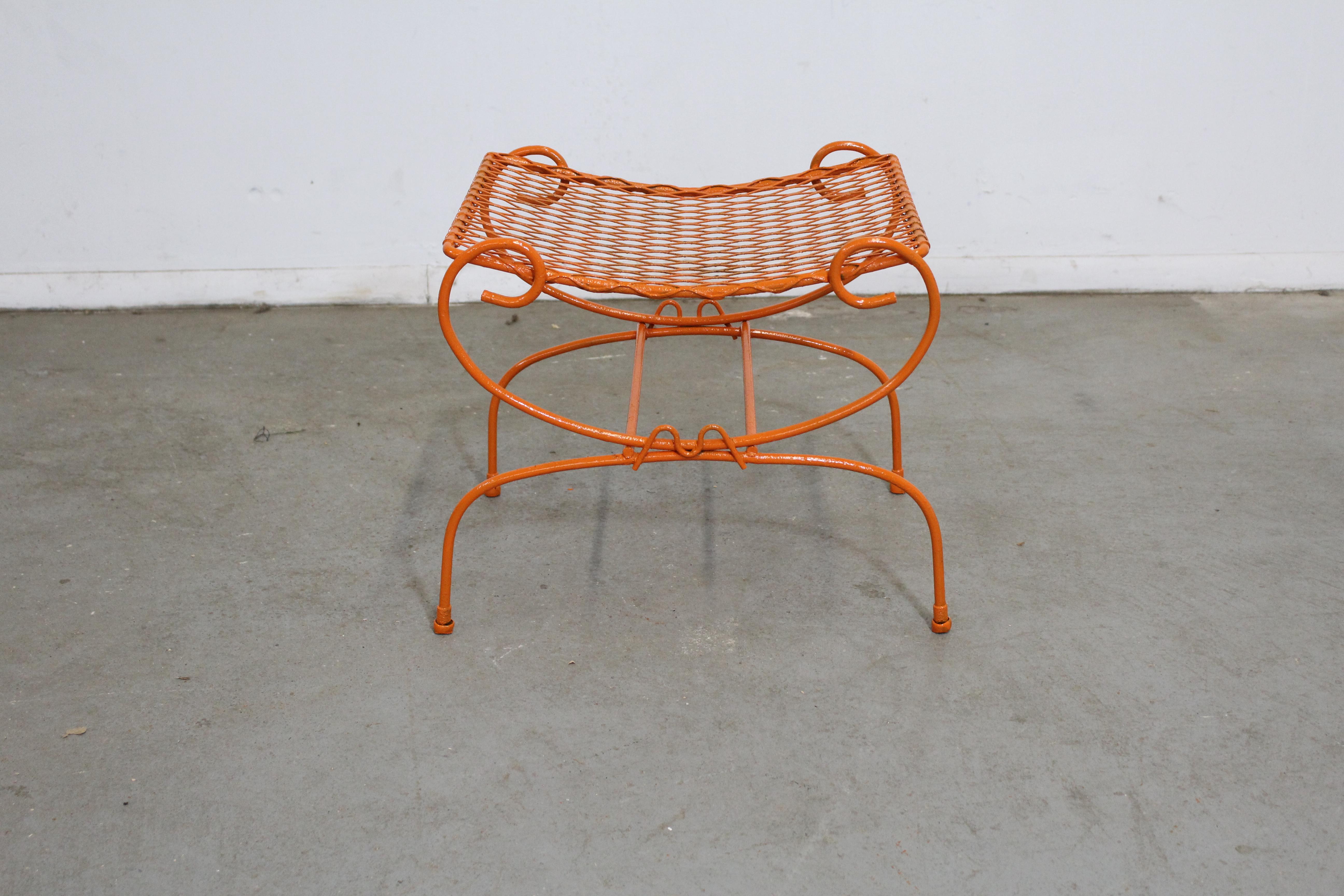 Offered is a vintage Mid-Century Modern atomic orange metal stool, circa 1960's. This piece is made of welded steel and features gracefully styled legs and a mesh top. It is in good condition considering its age with minor age wear (surface wear,