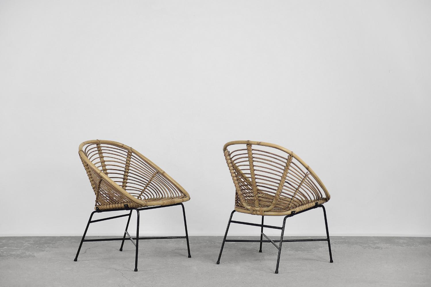 Cet ensemble de deux fauteuils vintage a été produit dans les années 1960. Le cadre était en métal noir, et le siège en forme de seau était tissé en bambou naturel.

Les fauteuils sont dans un état original vintage. Ils présentent des traces