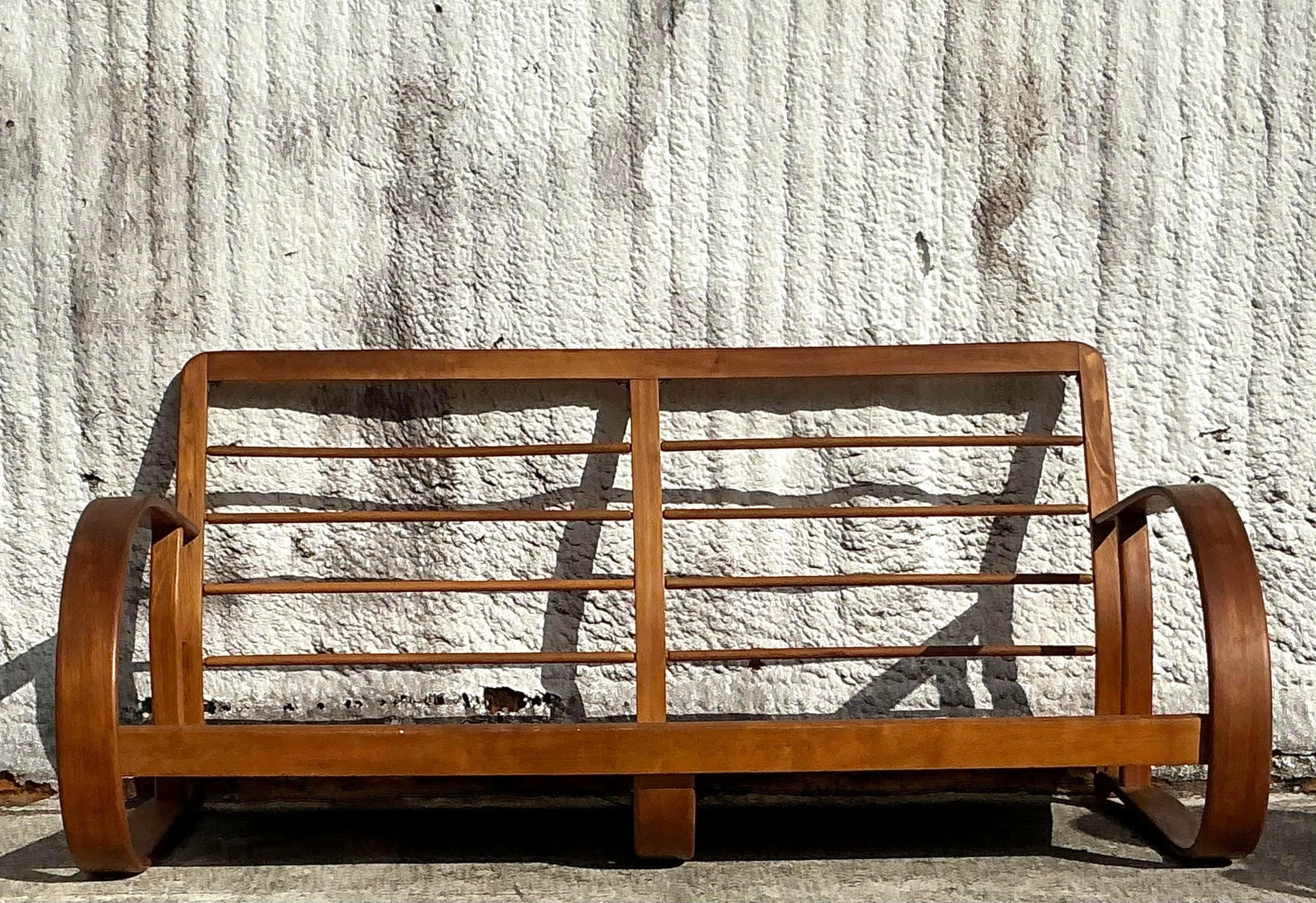 Élevez votre espace de vie avec ce superbe canapé Vintage Mid-Century Modern Bent Wood, inspiré par les designs emblématiques de Gilbert Rohde. Doté d'un cadre en bois courbé gracieux, ce canapé incarne les lignes épurées et organiques qui