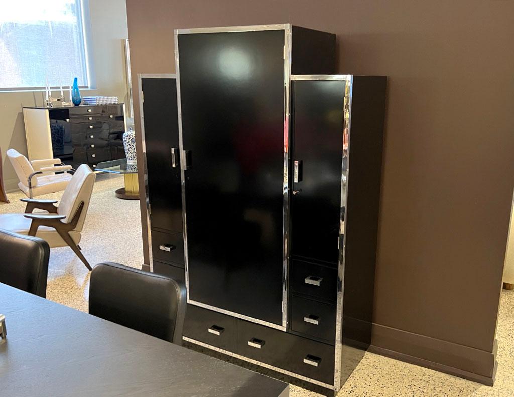 Vintage Mid-Century Modern Black Bar Cabinet by Heal’s. Iconic Mid-Century modern styling with incredible stainless steel accents throughout the cabinet. Newly restored in a satin black lacquered finish. Retrofitted with all new interior lighting