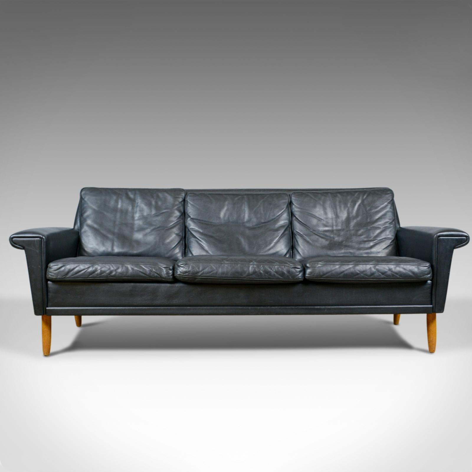 This is a vintage Mid-Century Modern black leather sofa. A Danish, three-seat sofa dating to the mid-20th century, circa 1970.

Classic Danish design with clean and simple lines
Finished a quality black leather
In good condition throughout