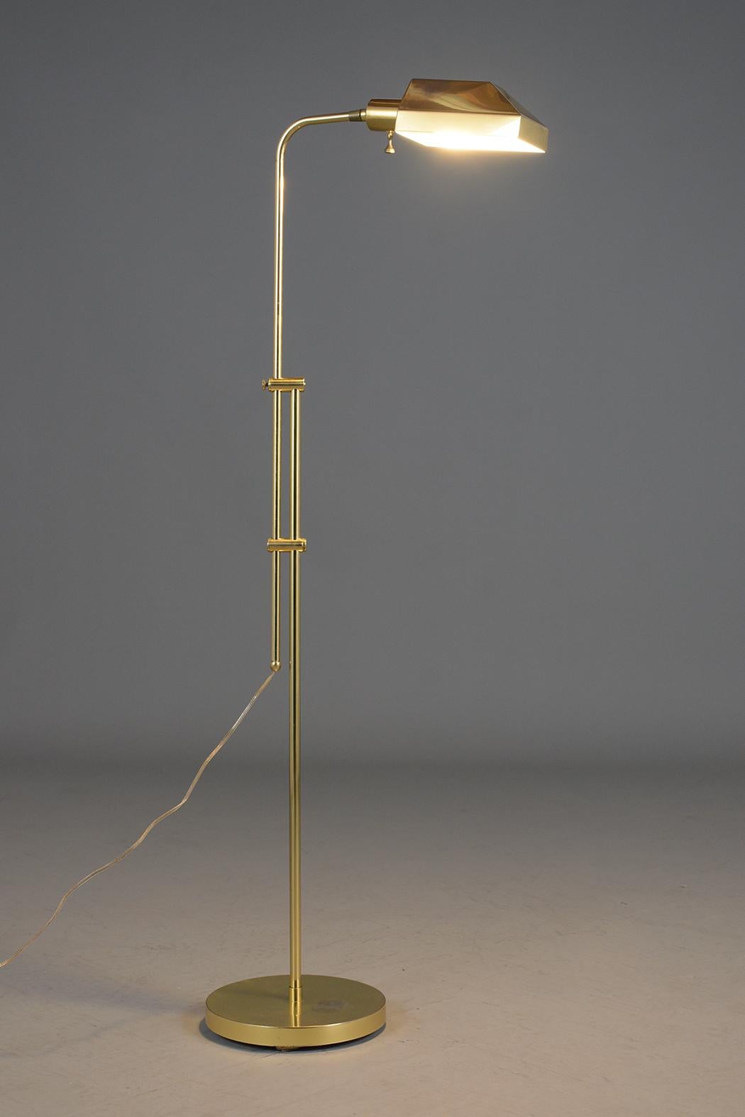 A vintage mid-century floor lamp made out of brass with a round base and in good condition. This fabulous lamp features an adjustable neck and shade and has a beautiful patina with a unique distressed finish from used in age. The 1960's brass lamp