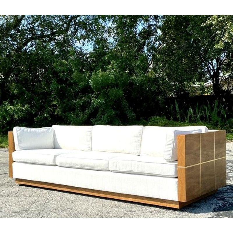 Ancrez votre espace de vie avec le profil sophistiqué de ce superbe canapé vintage case. Exemple par excellence du design américain du milieu du siècle, il se caractérise par un magnifique cadre en bois qui crée une ligne architecturale nette sous