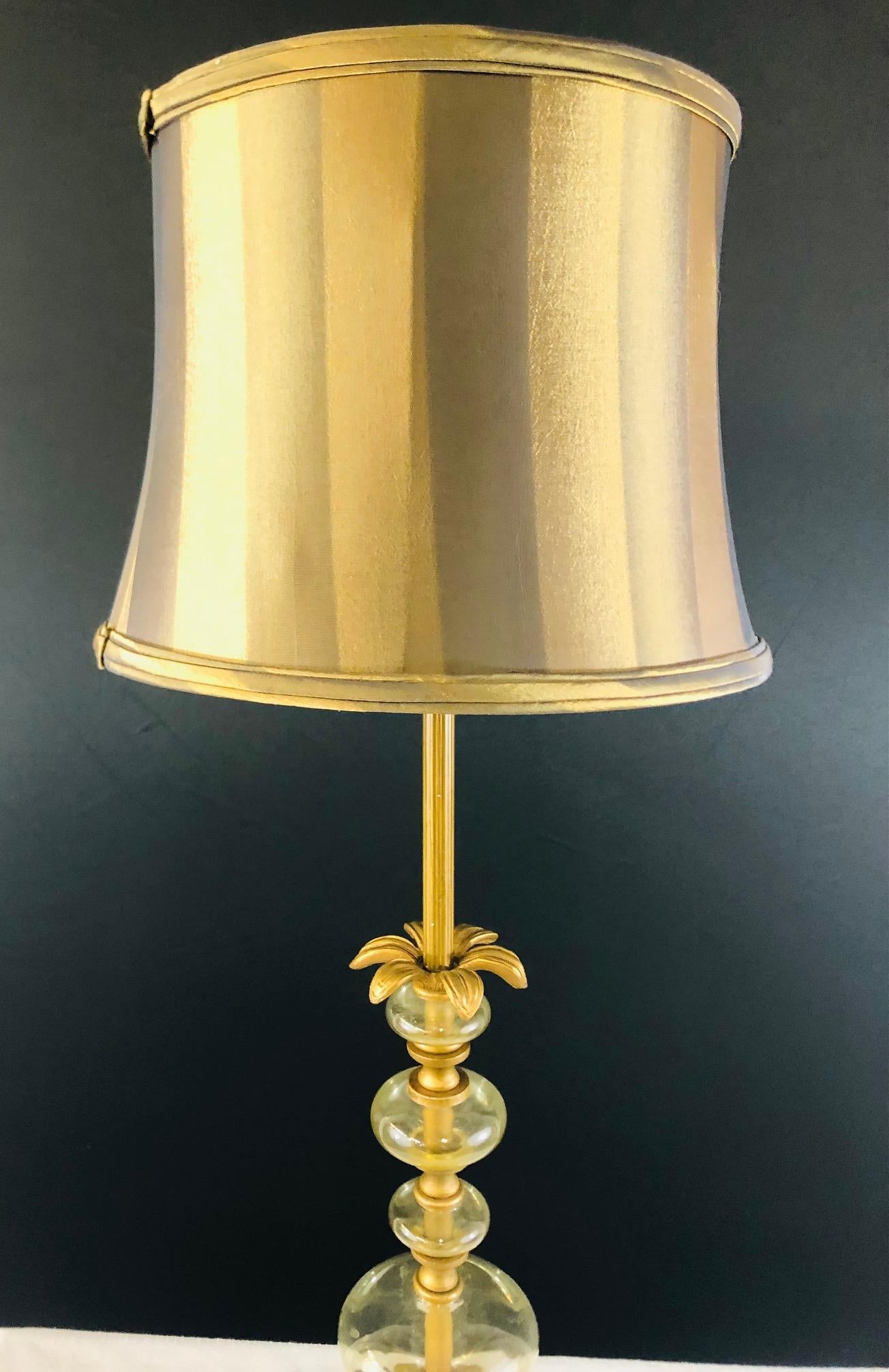 An elegant and stylish Mid-Century Modern table lamp in a brass palm tree style with glass design around the pipe and fine gold and brown color custom shade. This table lamp will light your room with style. 

Measures: Unit 30