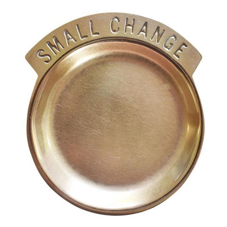 A Mid-Century Modern brass trinket dish. This dish is round and features the words 