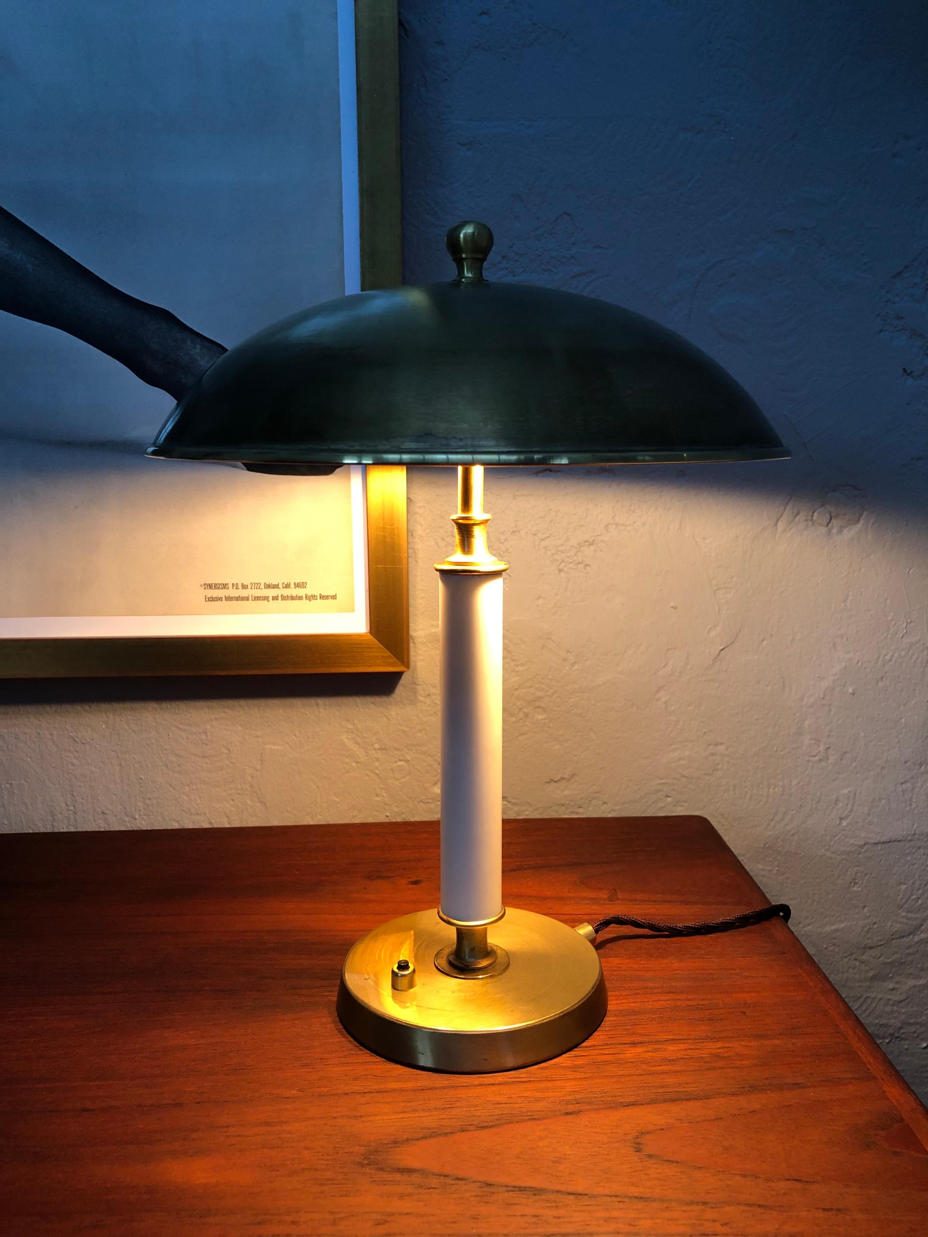 Vintage mid century modern table lamp in brass. 
All brass modernist table lamp with a white Bakelite stem. 
Brass shade with to E27 lamp holders in Bakelite. 
All new wiring with a new brass on/off switch and grounded. 
Can be fitted with an EU UK