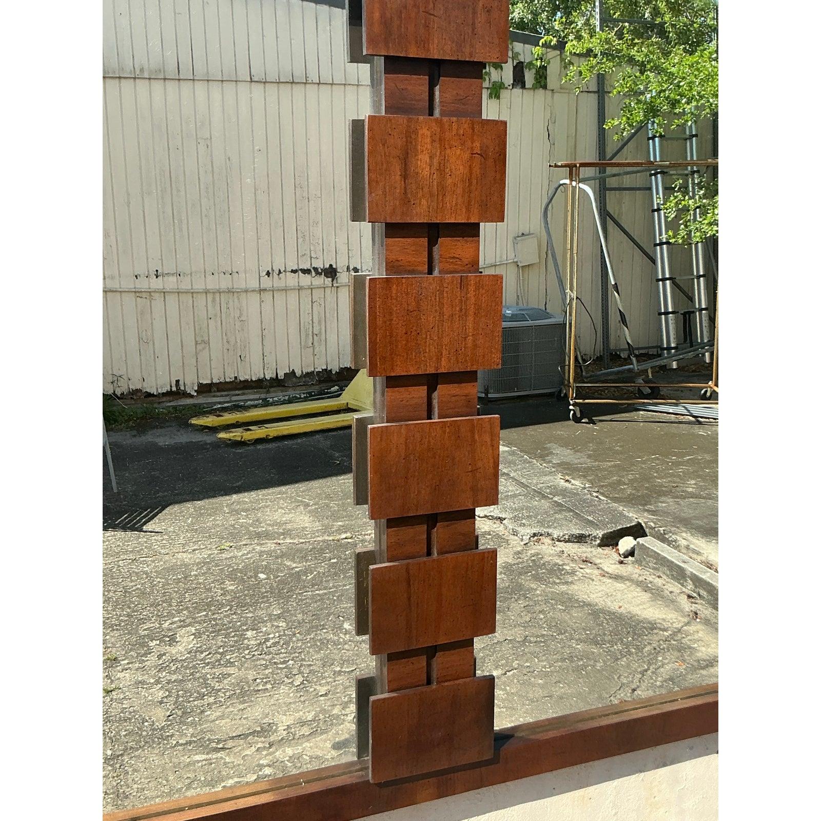 Ce miroir Brutalist de style moderne du milieu du siècle présente un design géométrique audacieux qui exsude le charme de l'architecture. Encadré en bois riche avec une pièce centrale sculpturale en blocs empilés, ce miroir illustre le savoir-faire