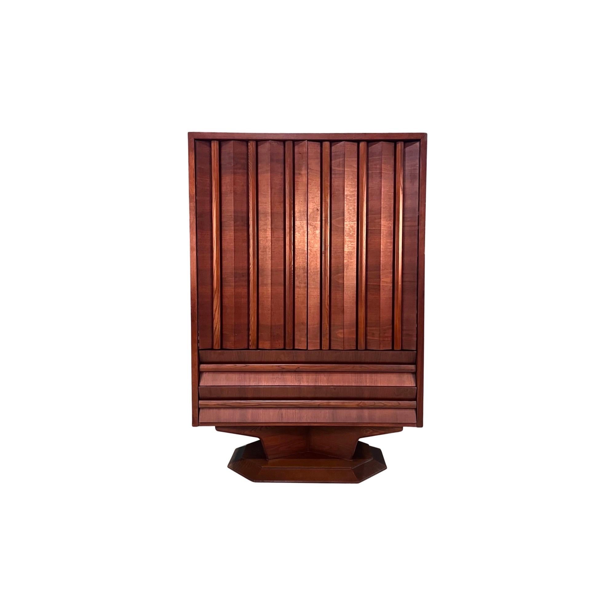 This is a unique walnut dresser with an octagonal base and pleated doors and drawer fronts. This dresser has ample storage: two lower drawers underneath the doors of this highboy armoire which open to four pullout drawers on the left and two