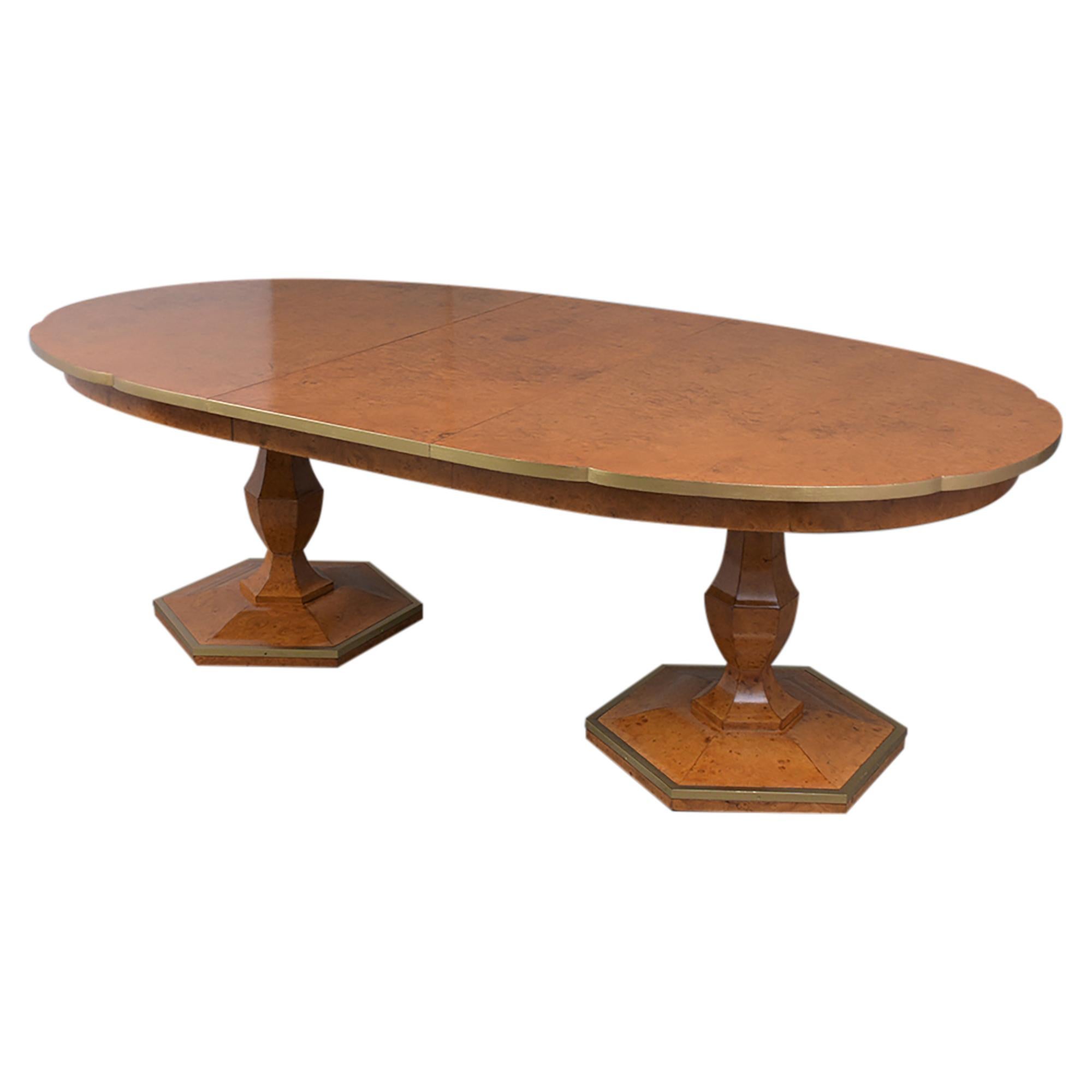 This vintage mid-Century modern dining table has been professionally restored and is hand-crafted out of wood covered in an exotic burl veneer newly stained in golden color with gilt accents and a lacquered finish. The table had a unique curved edge