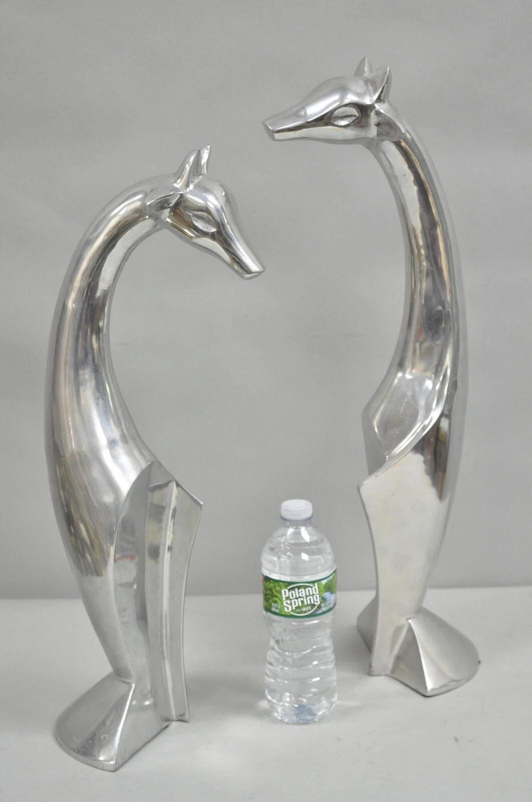 Vintage Mid Century Modern Cast Aluminum Silver Giraffe Sculptures (one a bit taller than the other) - a Pair. Circa Late 20th Century. Measurements: Tallest: 23
