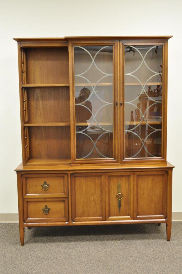 Vintage Mid-Century Modern walnut China cabinet by Century Furniture. Item features two upper swing doors with metal lattice, open bookcase to the left of the doors, lower swing doors, two dovetail constructed drawers, unique solid brass hardware.