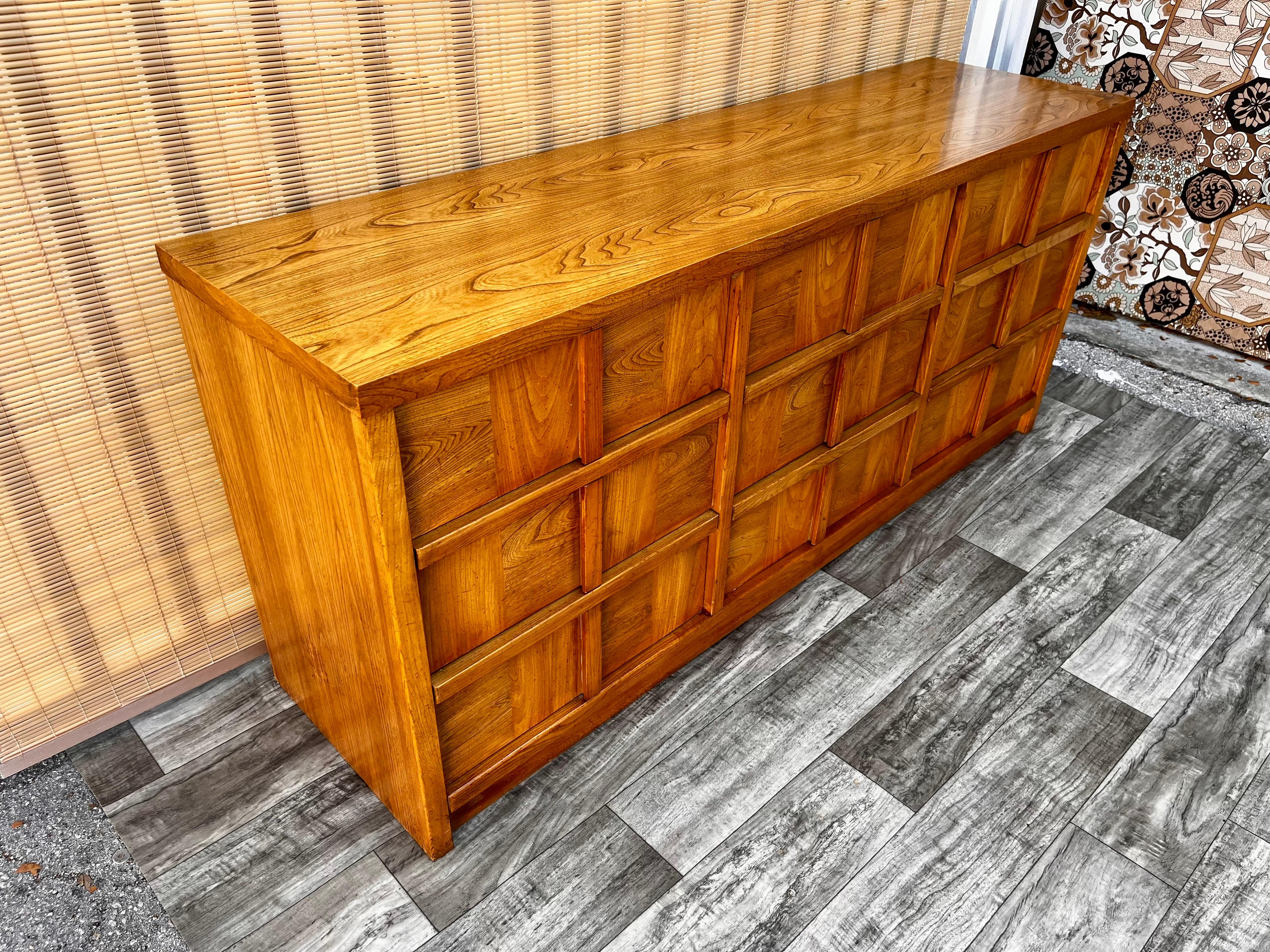 Vintage Mid-Century Modern chest of drawers by Stanley Furniture. circa 1970s.
Features a brutalist inspired design, nine drawers with concealed handles, and beautiful blond walnut wood grain.
In excellent original condition with very minor sings