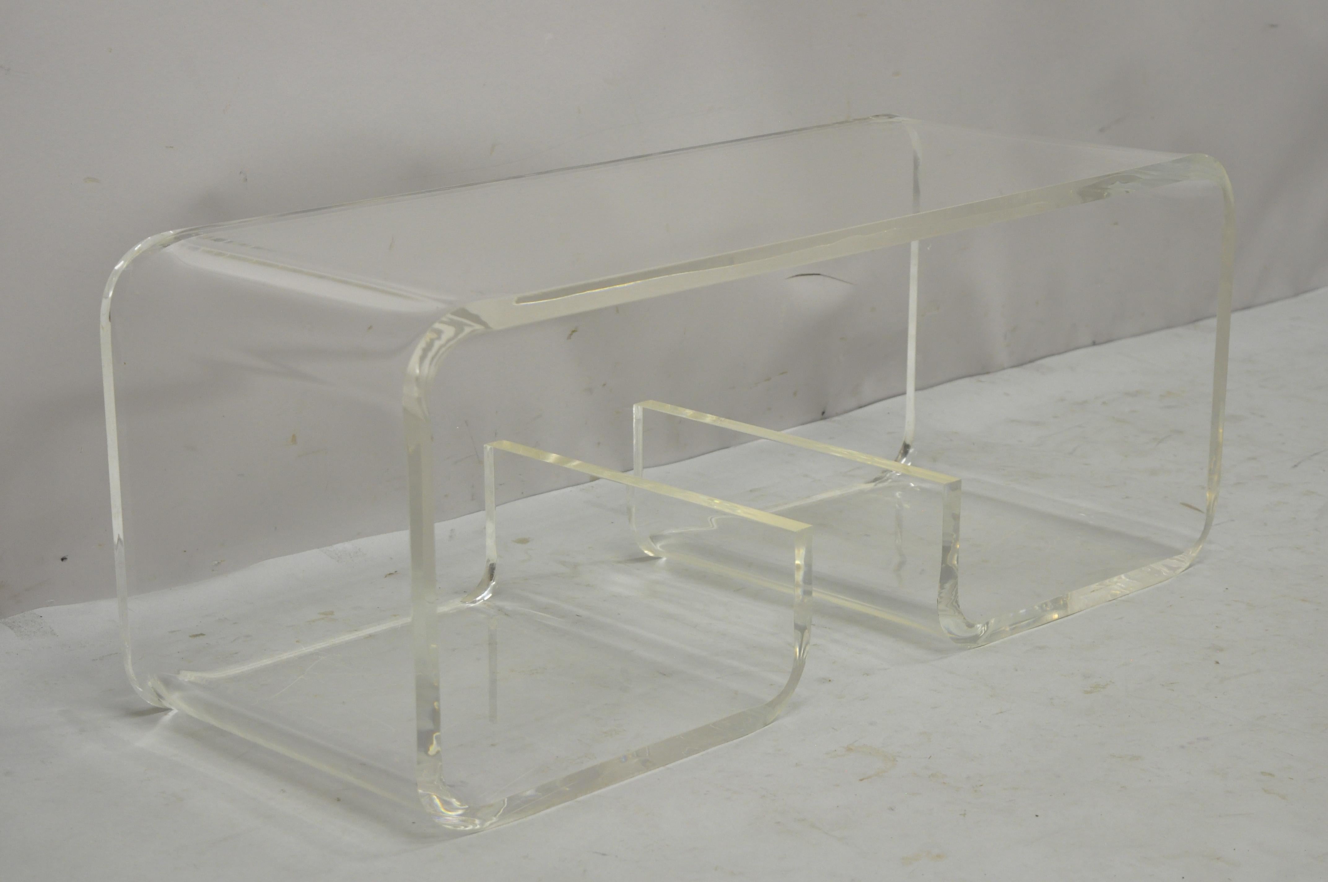 Vintage Mid-Century Modern clear lucite scroll coffee table after Charles Hollis Jones. Item features thick heavy clear lucite construction, scroll design, clean modernist lines, quality American craftsmanship, sleek sculptural form. Circa 1970s.