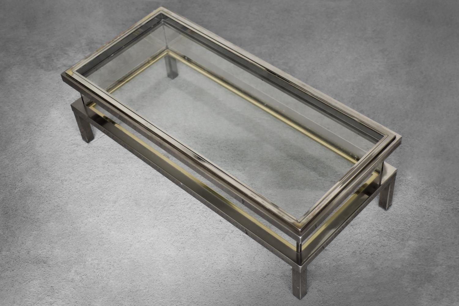 Cette table d'appoint sophistiquée a été conçue par la Maison Jansen et fabriquée en France dans les années 1970. Le cadre présente une finition métallique dorée et chromée totalement originale. La table présente une belle patine. La partie