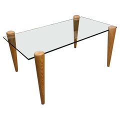 Mesa de centro vintage de mediados de siglo con tapa de cristal y patas de madera maciza