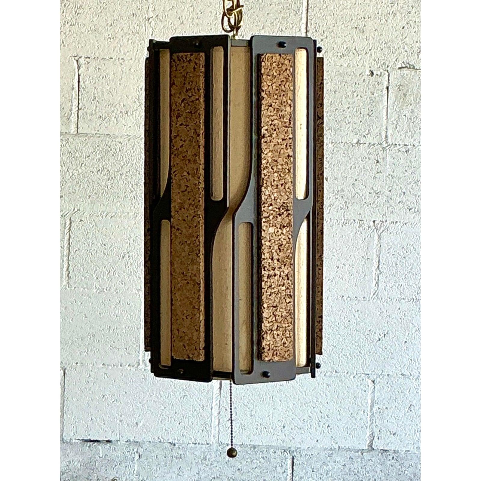 Cattura lo spirito quintessenziale del design anni '70 con questa suggestiva lampada a sospensione vintage. Capolavoro del modernismo organico, questo ciondolo presenta pannelli di sughero ricchi e strutturati incastonati in una scultorea cornice in