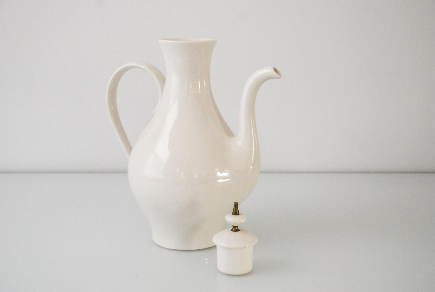 • Mid-Century Modern porcelain coffee pot from the 1960s.
• Minimalist design with sleek, elegant lines and gentle curves.
• Porcelain lid handle with brass detail.

Dimensions
Width (spout to handle): 9