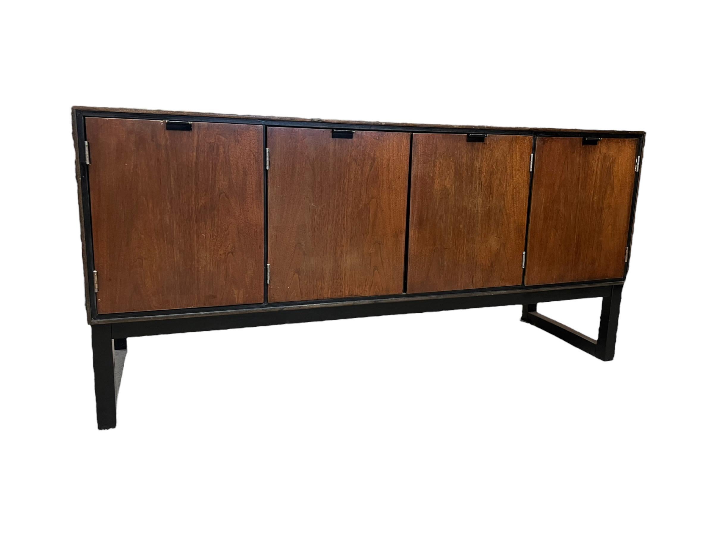 MCM Credenza by Stanley, walnut, brass and ebonized pulls on four doors, ebonized block feet, two interior drawers and shelves. Shelves are removable

Dimensions. 58W 18D 28H
Left cabinet inside : 13W 16D 15.5H
Center cabinet 28W 16D 15.5H
