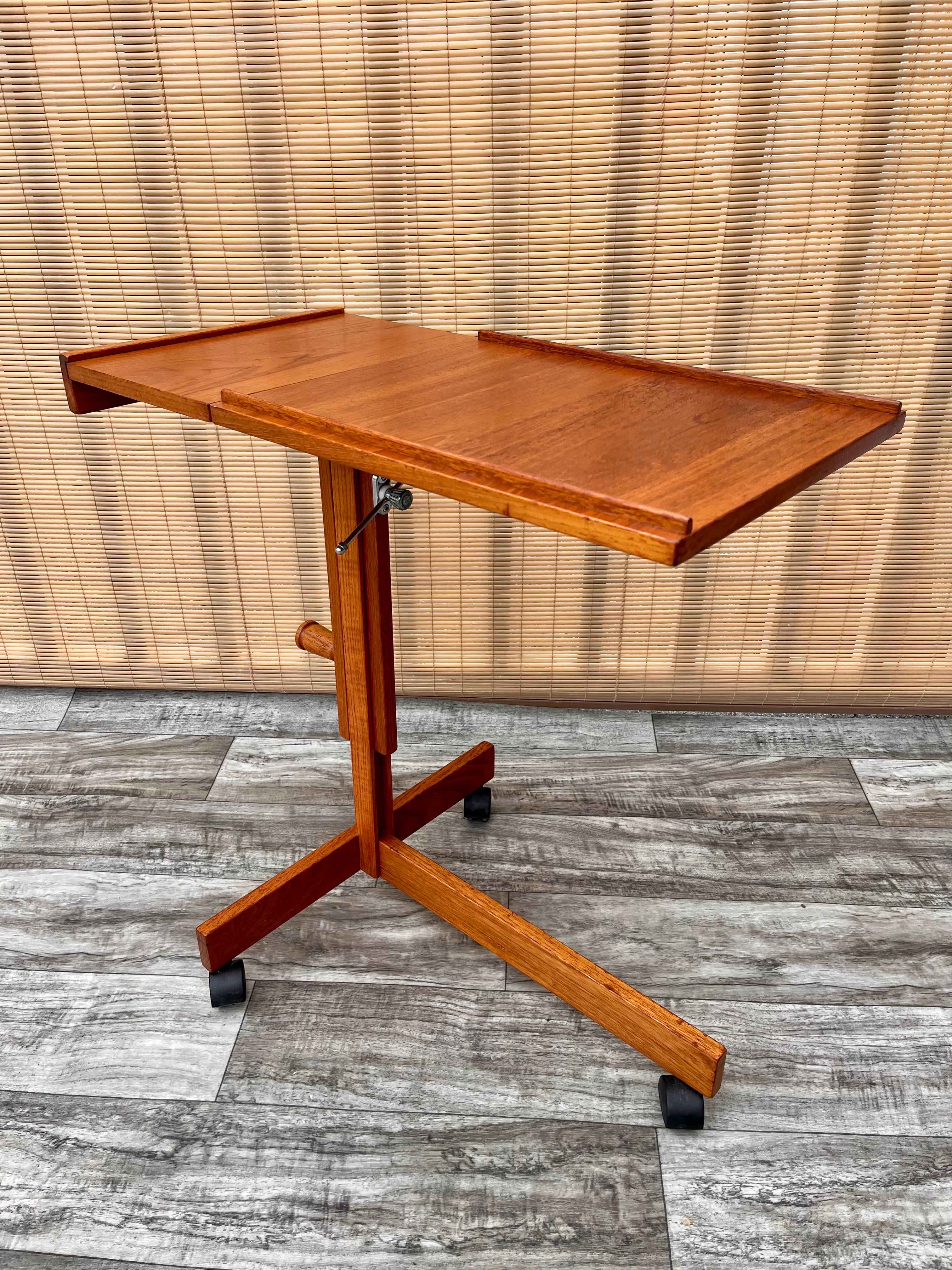 Vintage Mid-Century Modern Danish adjustable rolling tray table / cart. Circa 1970s.
Features a minimalist Scandinavian design, an adjustable tray table that can be raised from 28