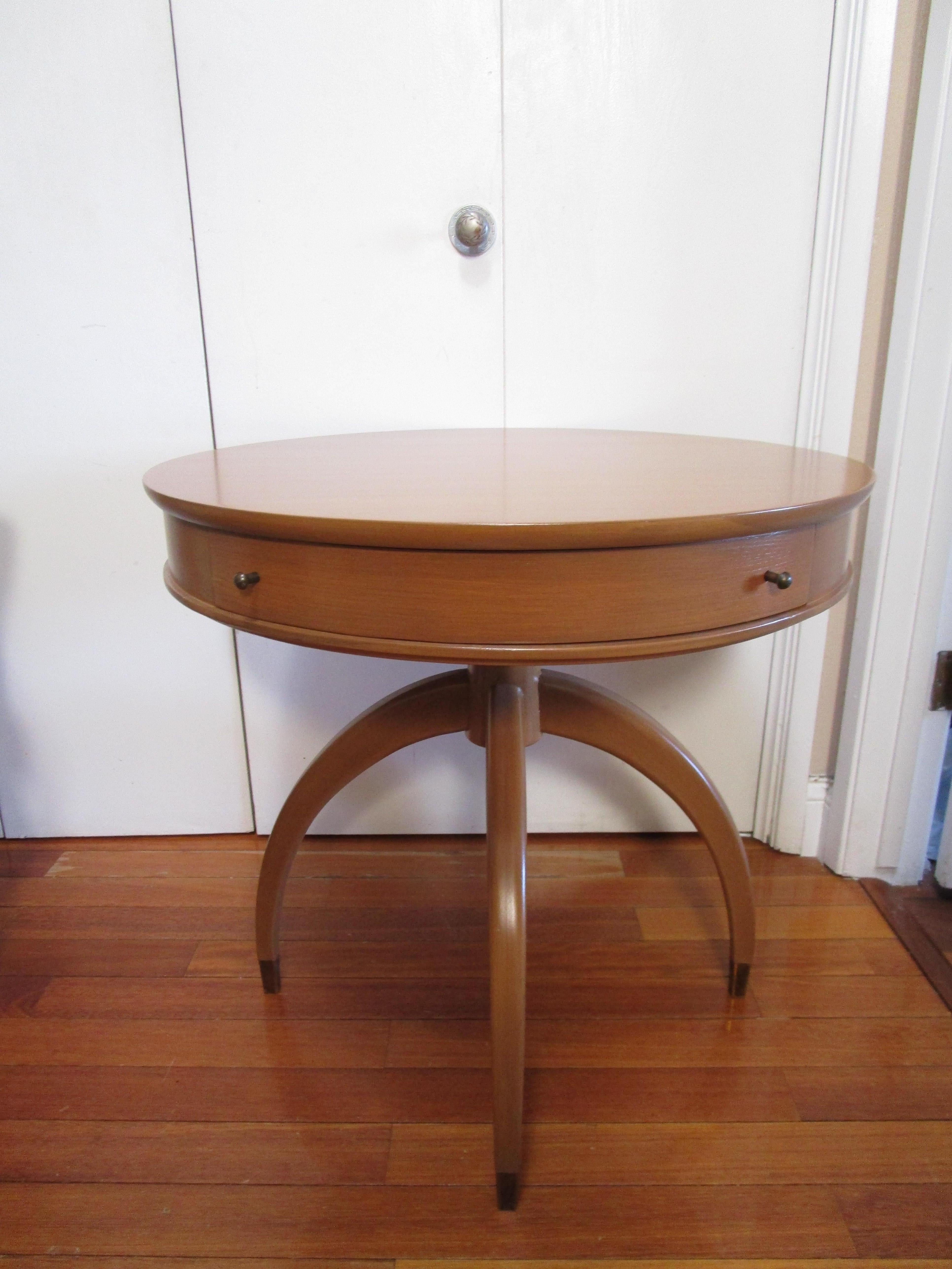 This is a circular mid-century modern table (unattributed) in the Danish style. It is beautiful in form, finish and function. The writing table has been refinished. It has a molded rail fitted with a drawer with two pulls that are original. The