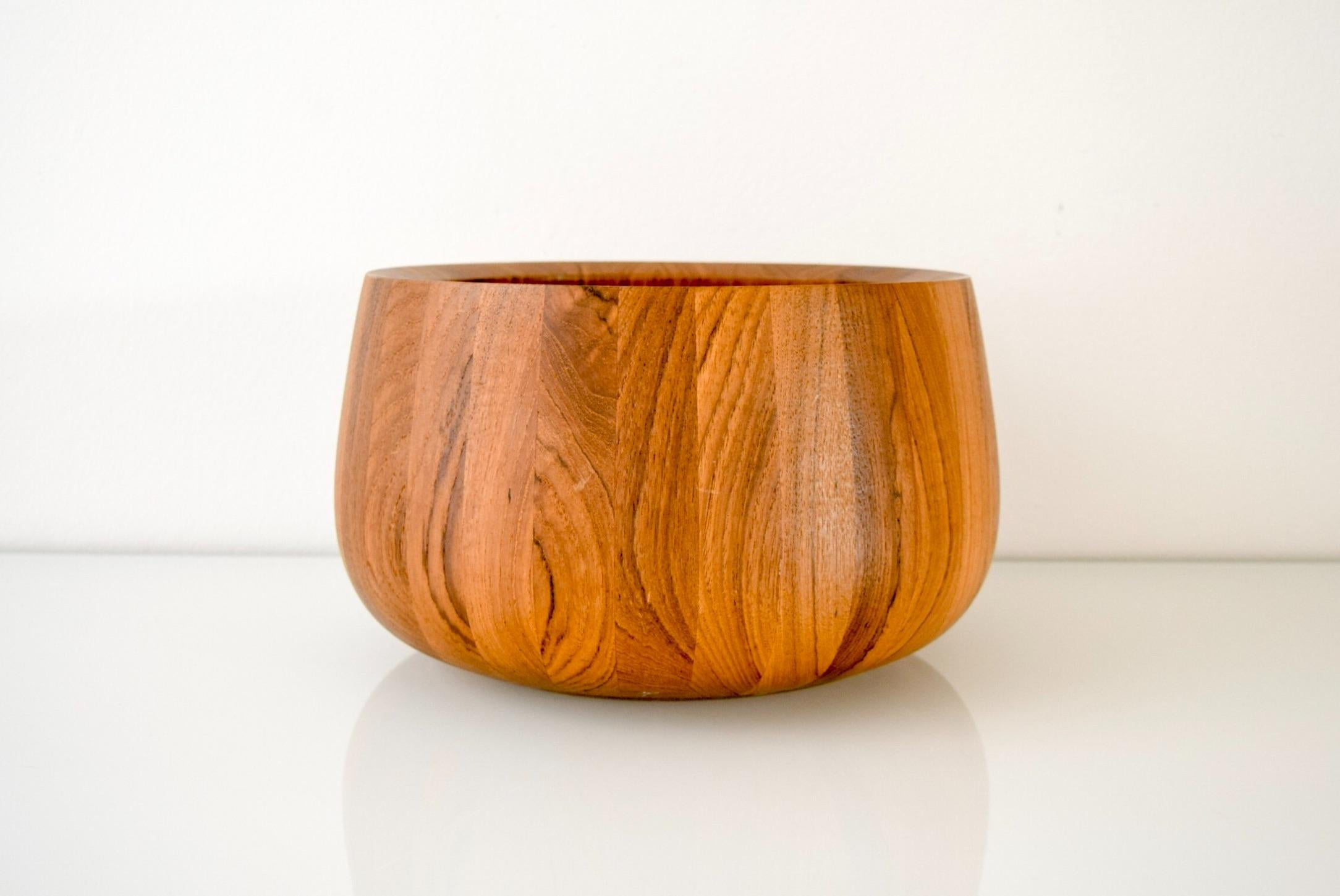 This large vintage midcentury Danish modern Dansk walnut wood fruit bowl is circa 1960. It is made from thick solid staved walnut with gorgeous grain and features a simple, elegant design with tall sides that angle in slightly to create a beautiful