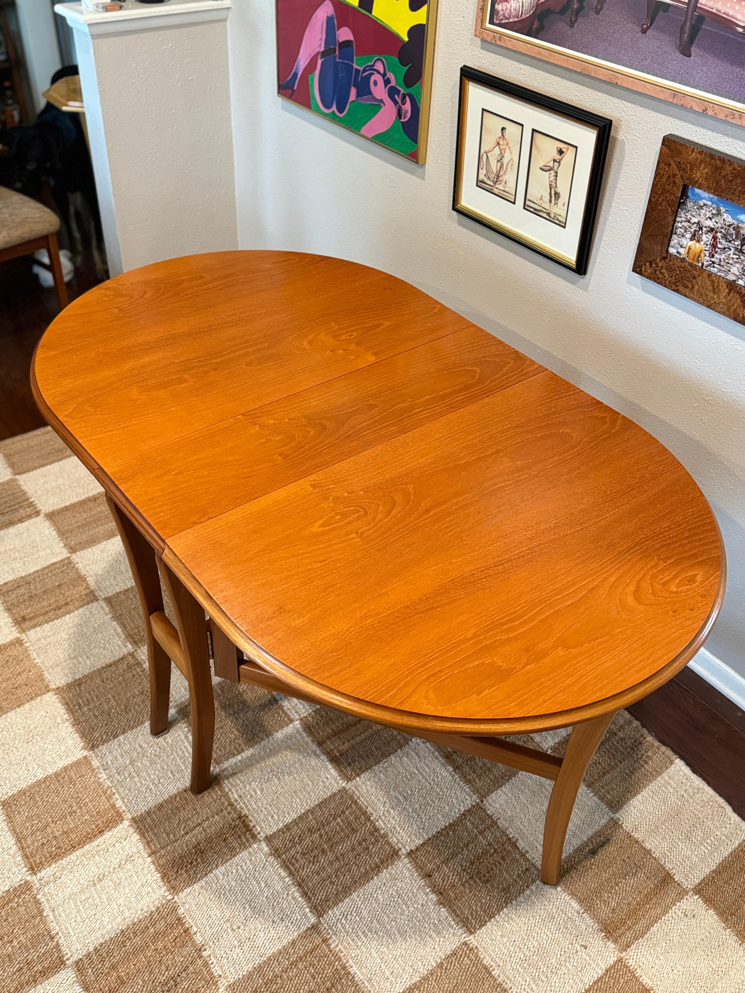 A mid century modern dining set including a drop leaf table and 4 dining chairs, circa 1970s. In the style of Benny Linden. Overall in very good original condition. The dining table is in amazing condition, and the chairs are in good condition with