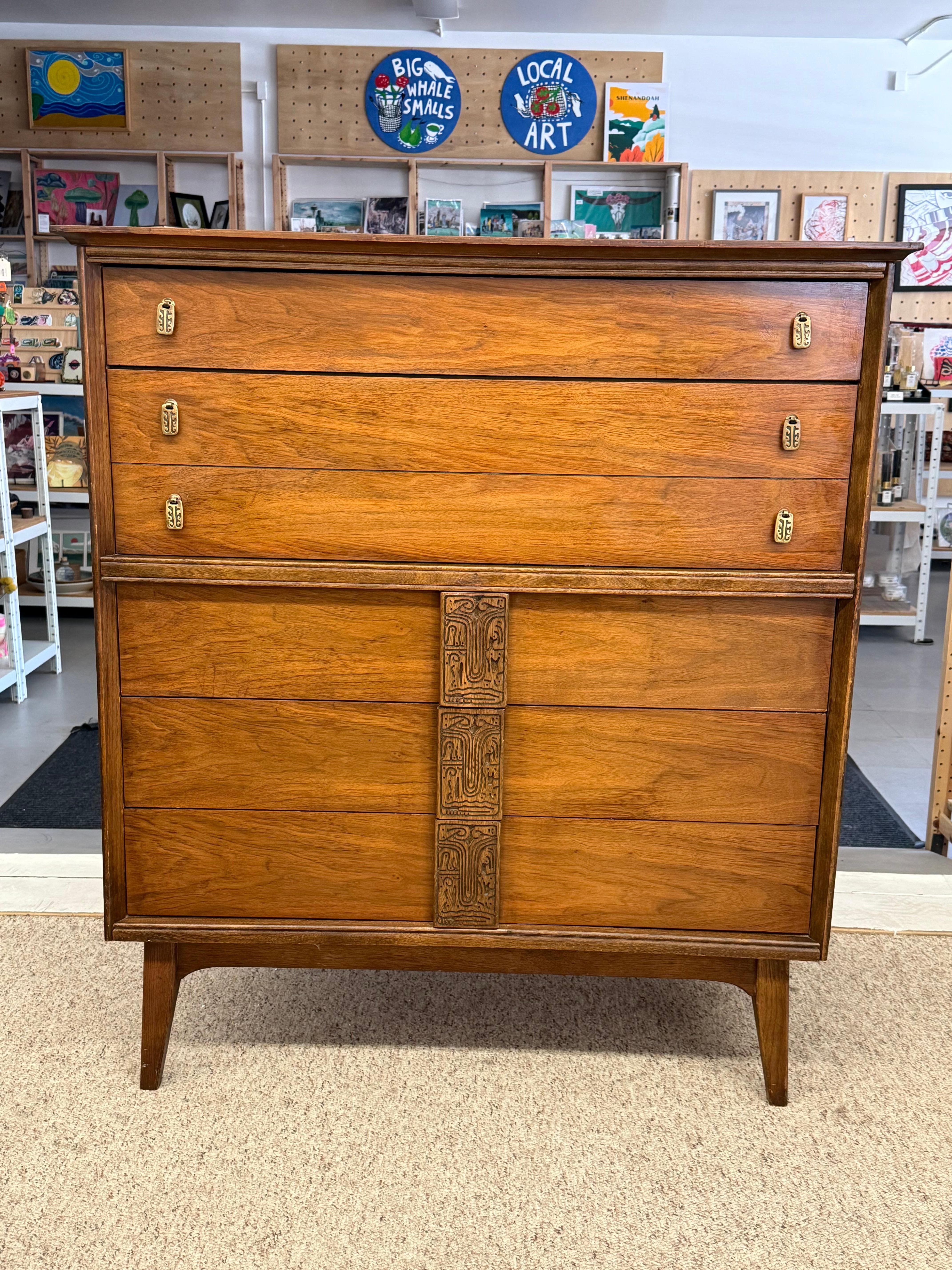 The Bassett Aztec dresser, designed by Leo Jiranek and produced from April 1963 to March 1967, is a standout piece from the Mid-Century Modern era with several unique features 
The dresser features intricately carved wooden handles and metal knobs