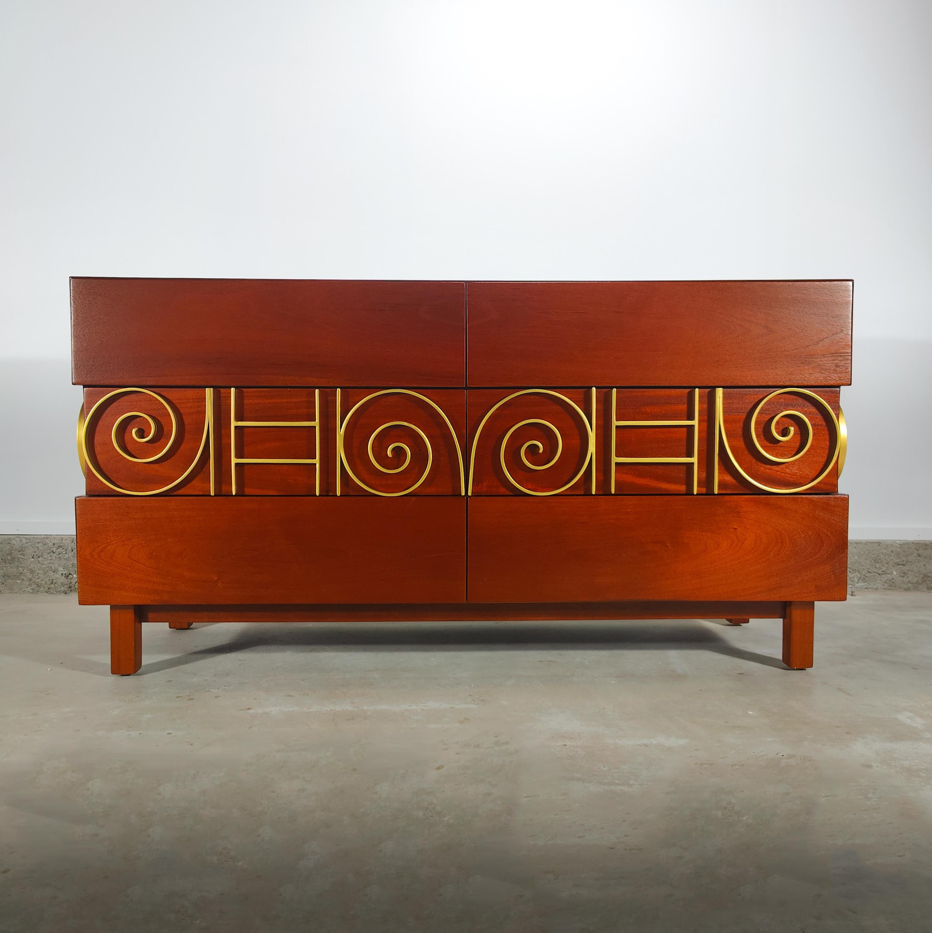 Now available is an important lowboy designed by Edmond J. Spence for Industria Mueblera of Mexico c1950s. Features freshly refinished mahogany wood, intricate metal designs, and cultured labels throughout each drawer to show authenticity. Truly a