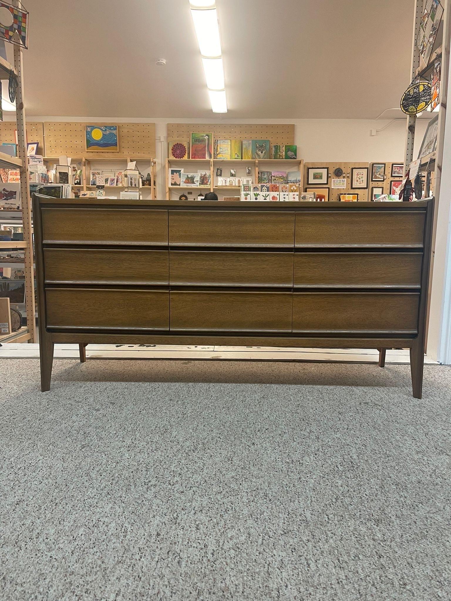 This Sleek 9 Drawer Dresser by United has Dovetail Drawers and Tapered Legs. Vintage Condition Consistent with Age as Pictured.

Dimensions. 60 W ; 18 D ; 30 1/2 H