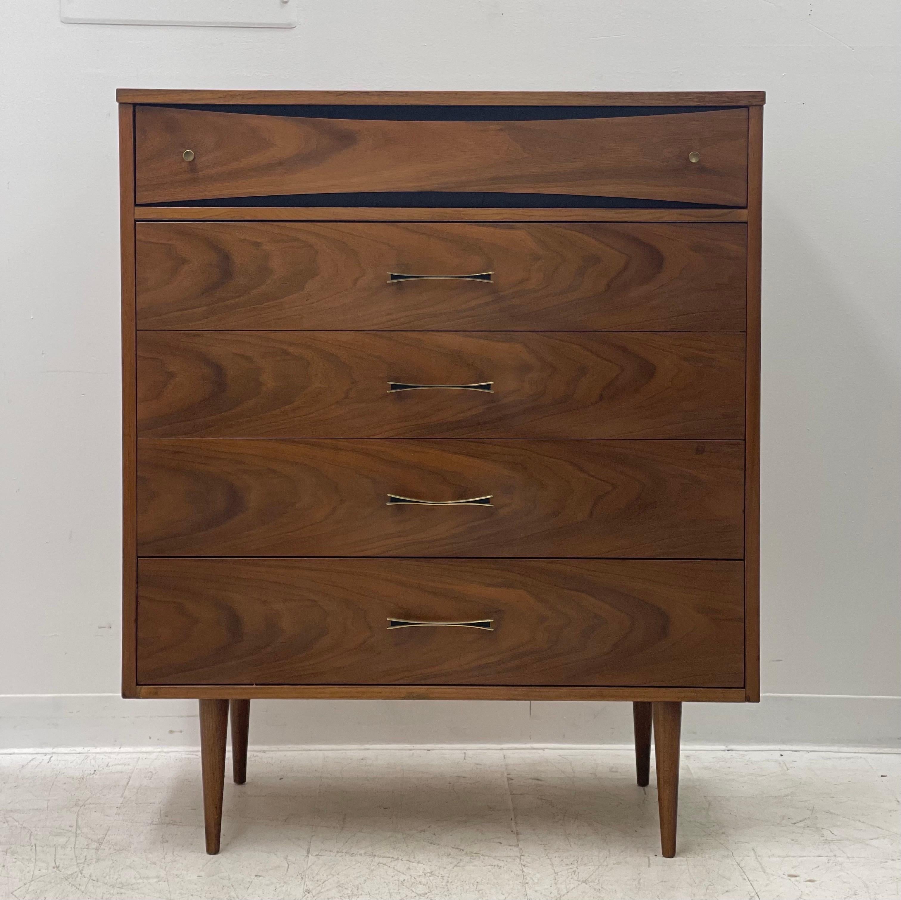 Vintage Mid-Century Modern dresser with dovetail drawers with bow-tie shape brass handles.

Dimensions. 36 W; 43 1/2 H; 17 D.