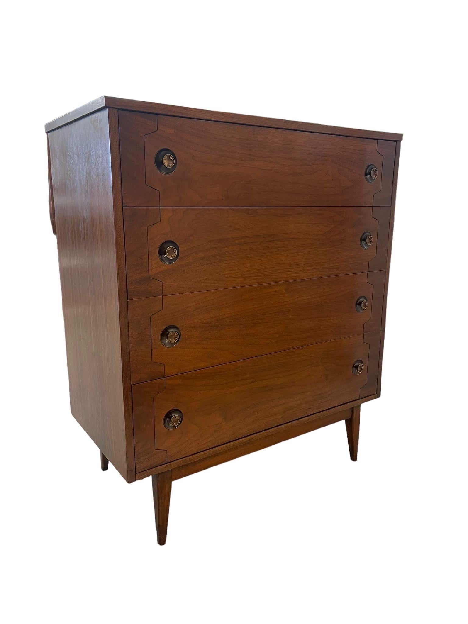Tallboy Dresser with Unique Circular Hardware Slightly indented into the wood. Geometric Design Featured on the Front of the Dresser Along with Tapered Legs. Vintage Condition Consistent with Age as Pictured.

Dimensions. 36 W ; 18 D ; 42 H