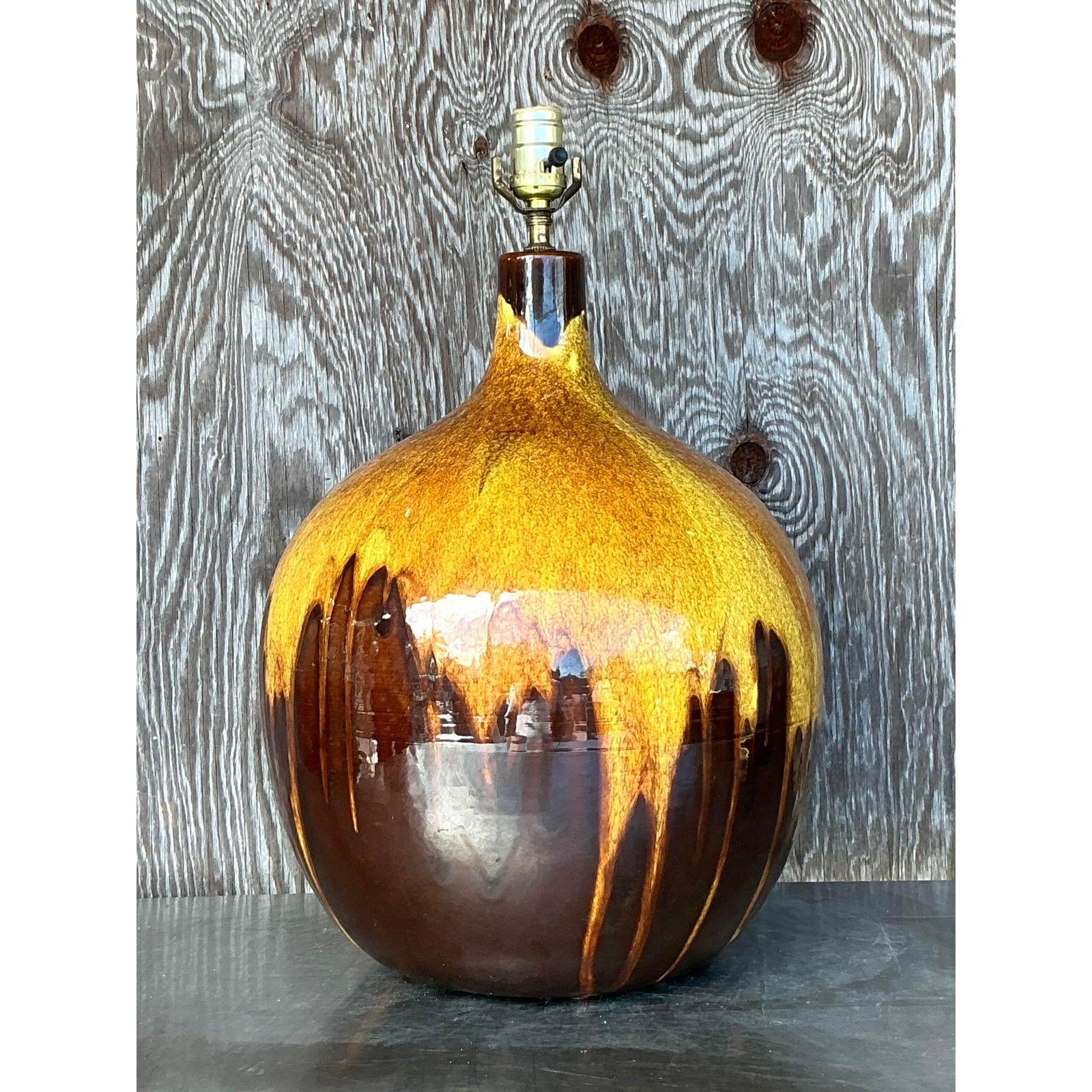 Cette superbe lampe vintage du milieu du siècle (MCM) à glaçure goutte à goutte est une véritable pièce d'apparat, avec un corps en céramique magnifiquement arrondi et une riche glaçure marron et jaune d'or qui tombe en cascade dans un motif